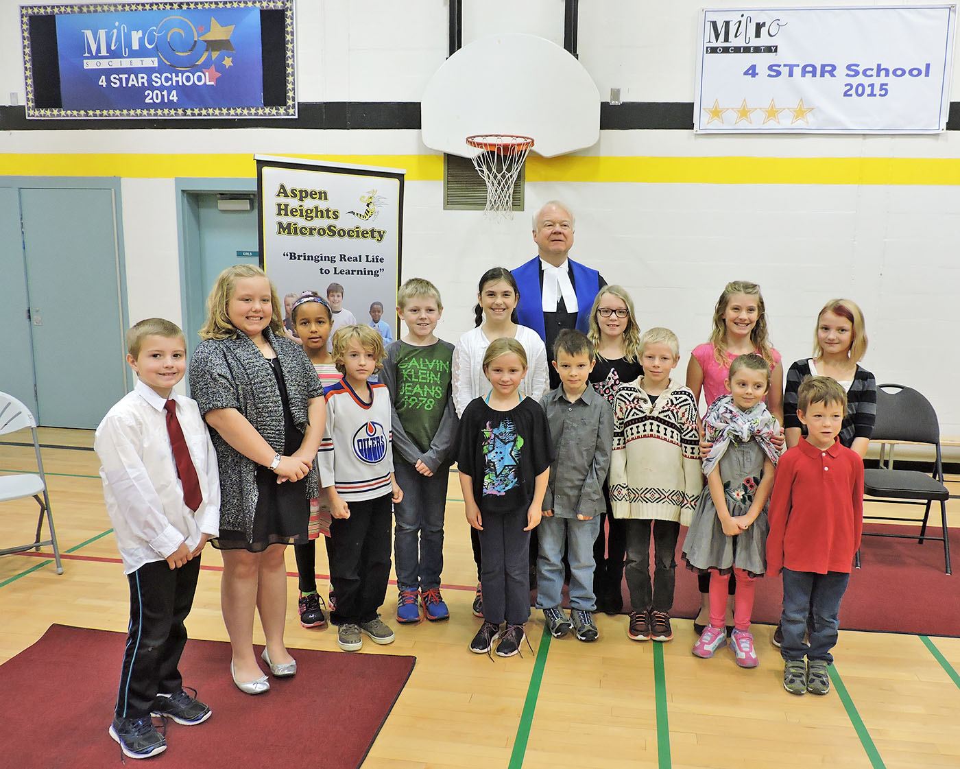 MICROSOCIETY - A group of Aspen Heights students stand with Judge Jim Mitchell at the swearing in ceremony for the MicroSociety. The school was recently honoured for its MicroSociety.