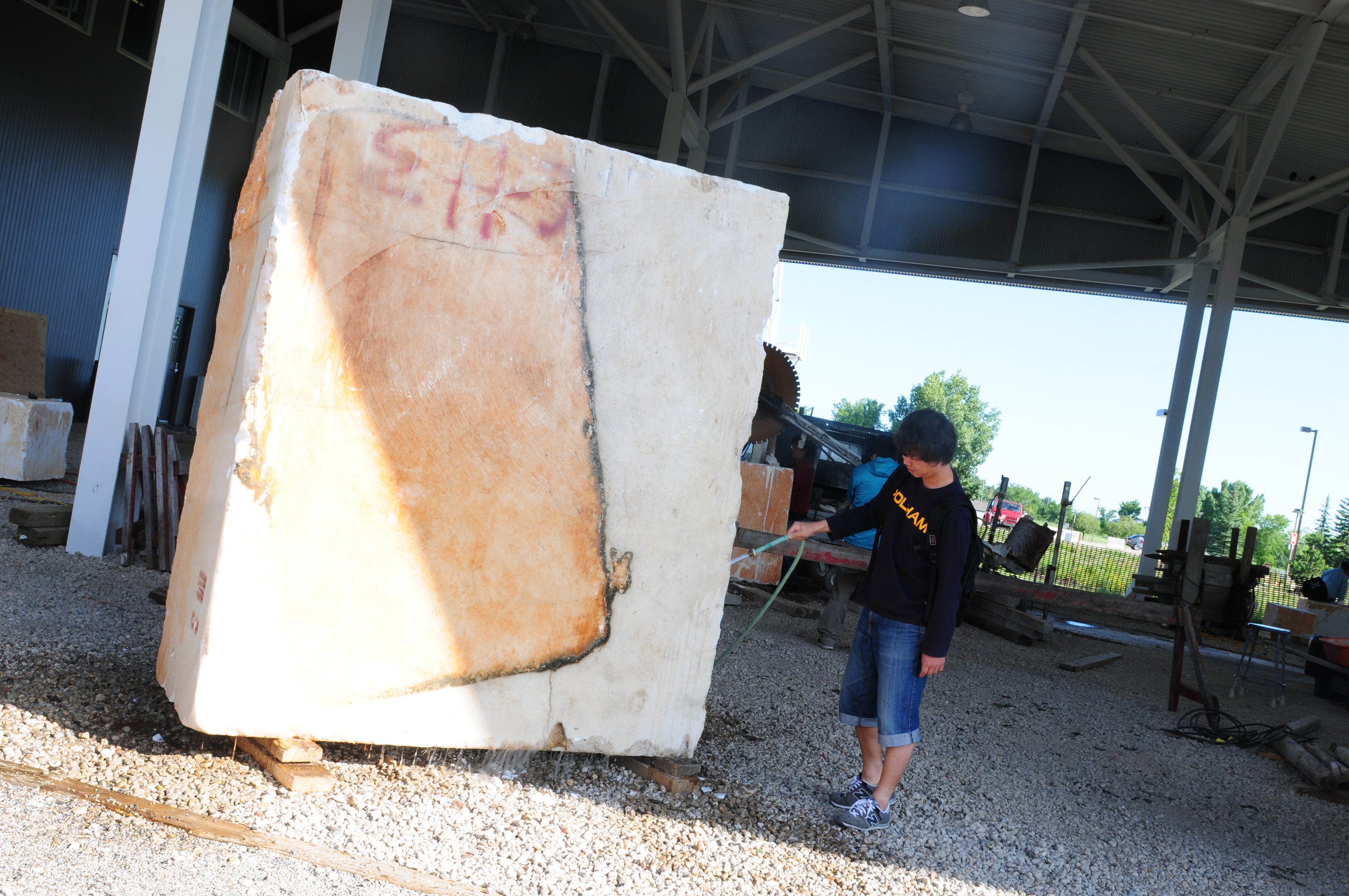 BATH TIME- Kim Bongsoo from Korea hoses down one of the giant rocks that will be carved during Bergen Rocks at the College.