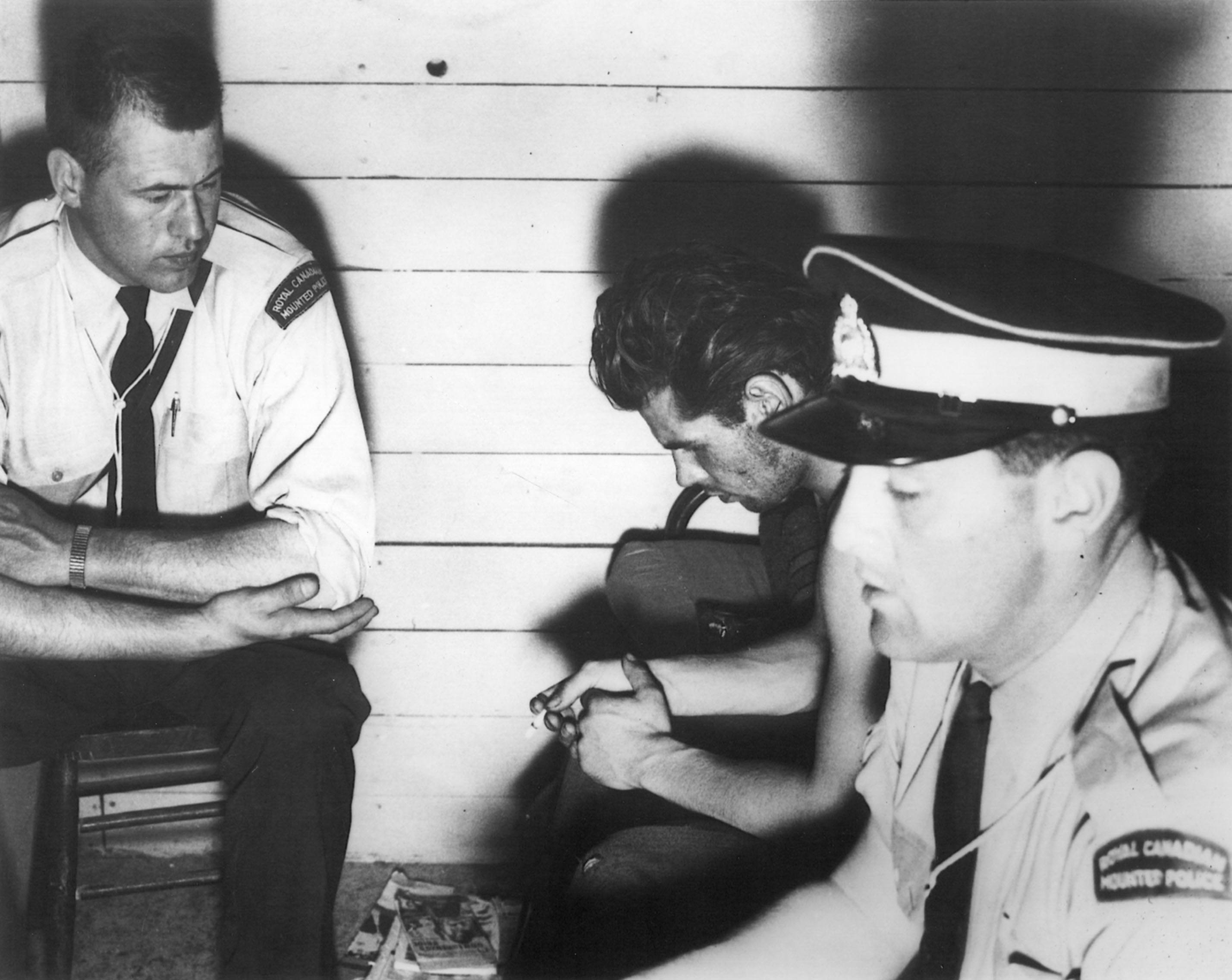 WAITING-Robert Raymond Cook waits with police at the RCMP Bashaw detachment cell block in June of 1959. After being accused of killing his family in Stettler