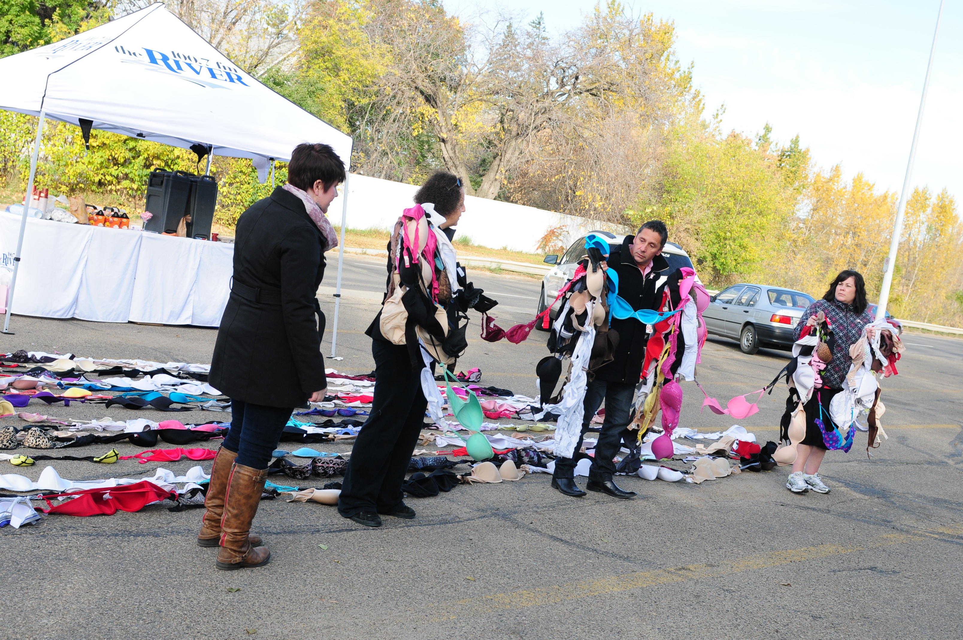 STOCKING UP- Team members from The River radio station get ready to hang donated bras across the Red Deer River in support of breast cancer.