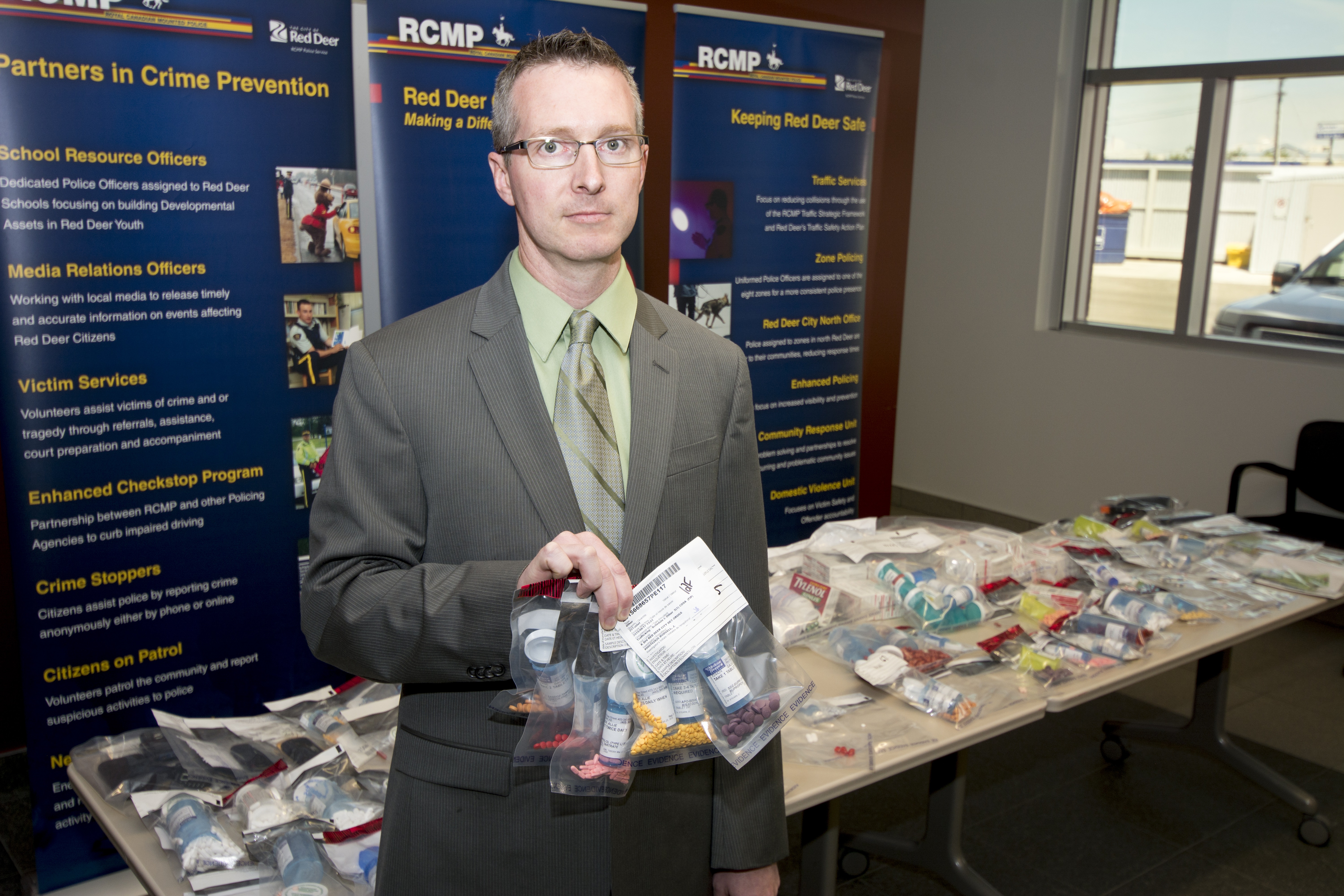 CHARGES LAID - RCMP Sgt. Eric McKenzie displays the recently seized items after a search warrant was executed in Red Deer. Allie Gader