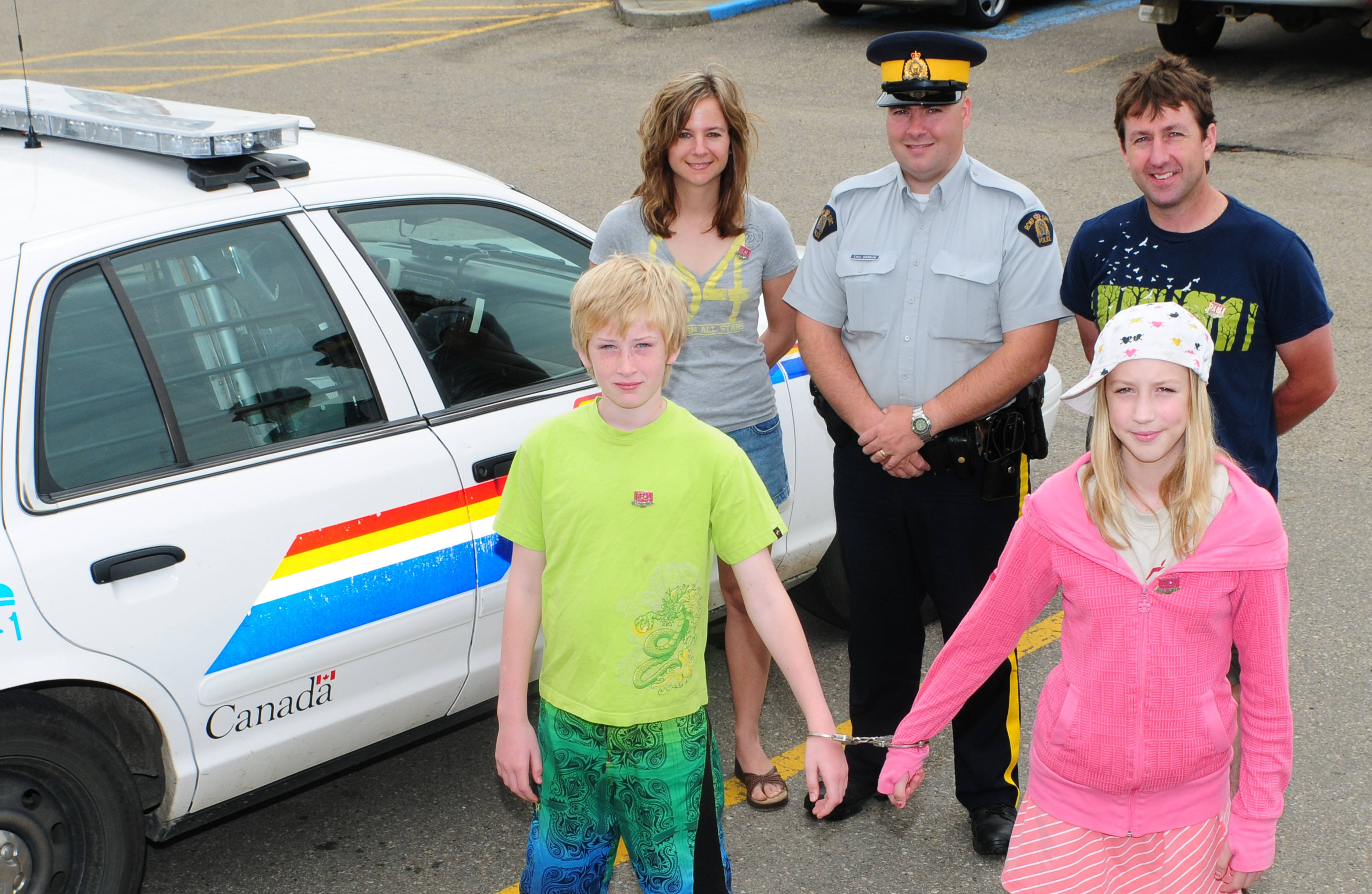 LUCKY ARREST- This year's Arrest-A-Guest family Steve Keddy and Theresa Lutz stand with Const. Tom Harnum