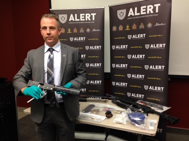 BUST - Insp. Chad Coles with the ALERT team stands with a MAC-11 subcompact machine gun