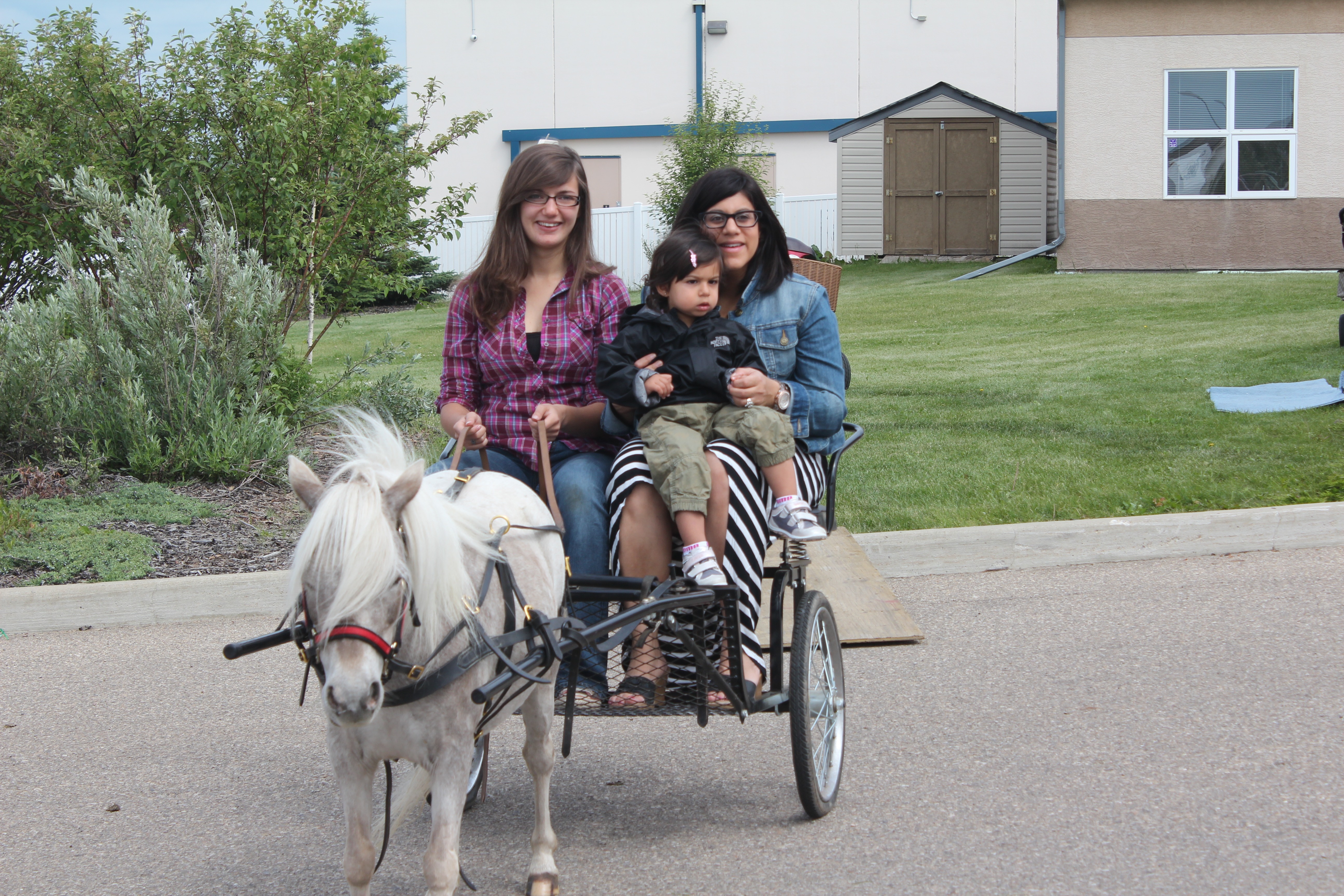 CARRIAGE RIDE- Shazma Charania and her daughter Reya enjoy a trot around the parking lot of the Davenport Church of Christ at an Old Time Country Fair this past weekend.