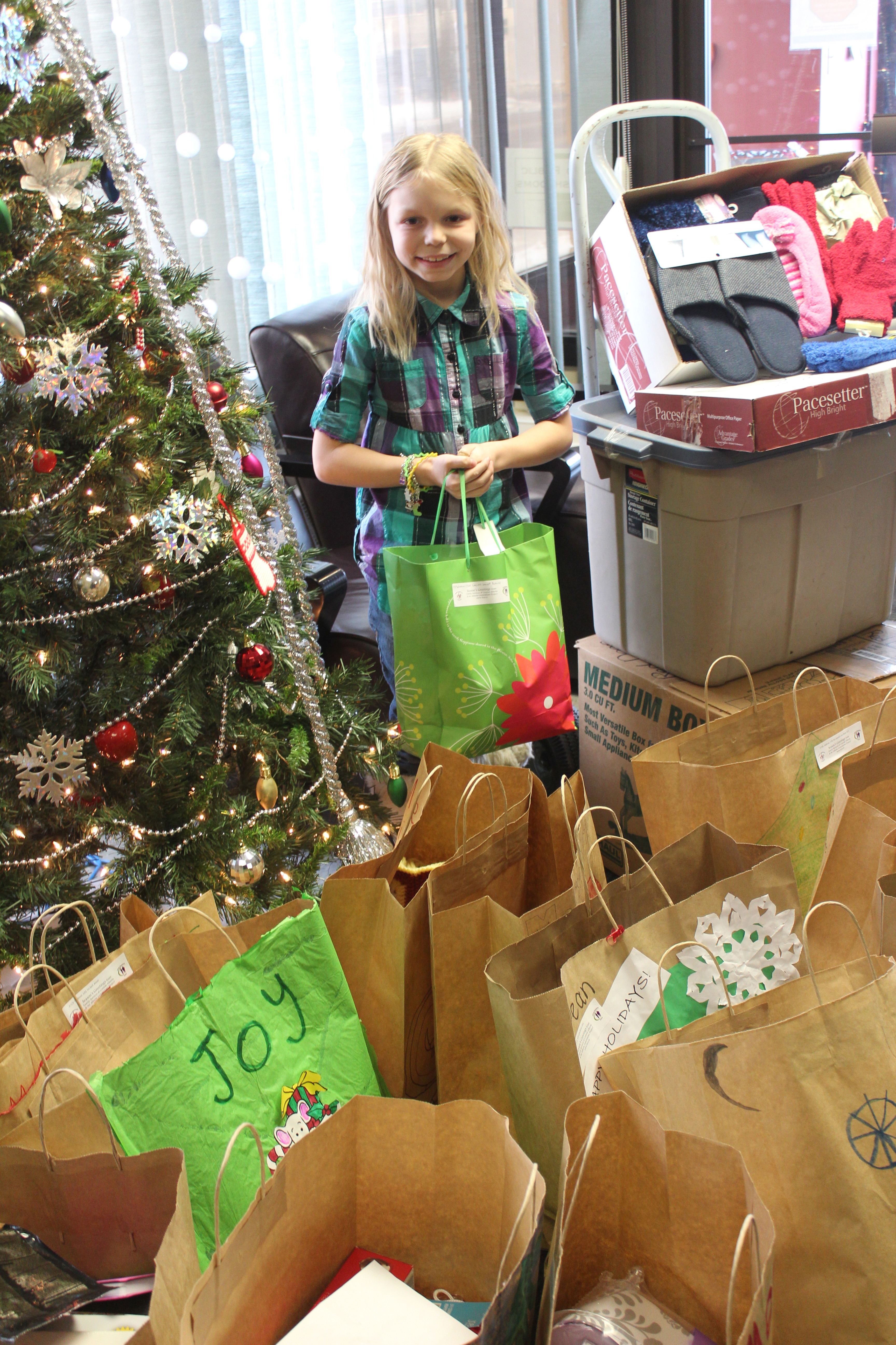 INSPIRATIONAL – Olivia Everitt-England of Red Deer is surrounded by donations to the Gifts for Grandparents program spearheaded by Family Services of Central Alberta. Olivia helped inspire many people to generously support the program this year.