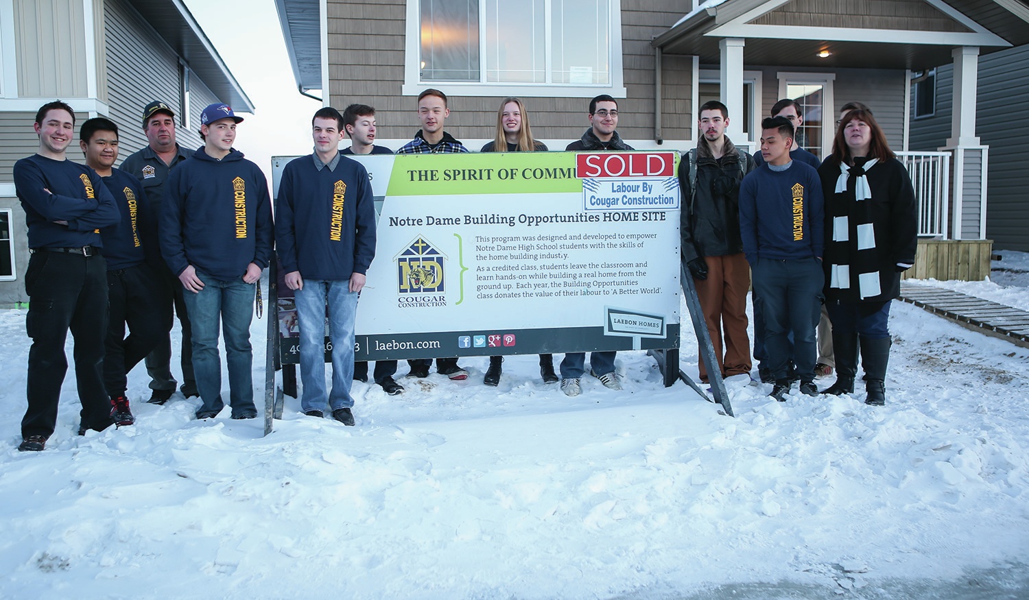 ACHIEVEMENT - Students from the Building Opportunities program at Notre Dame High School posed for a photo in front of the house they helped to build in Red Deer.