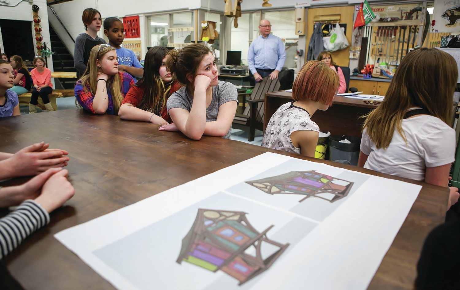 LEARNING - Students from Central Middle School's Sawing for Schools program sat at a dining room table they made with a number of local contractors during a media event at the school this week. The table