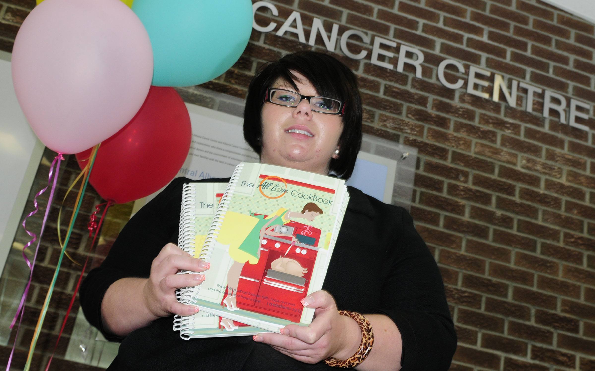 Brandi Johnson shows off her cook book at the Cancer Centre in Red Deer where she is selling them to raise money for cancer patients.