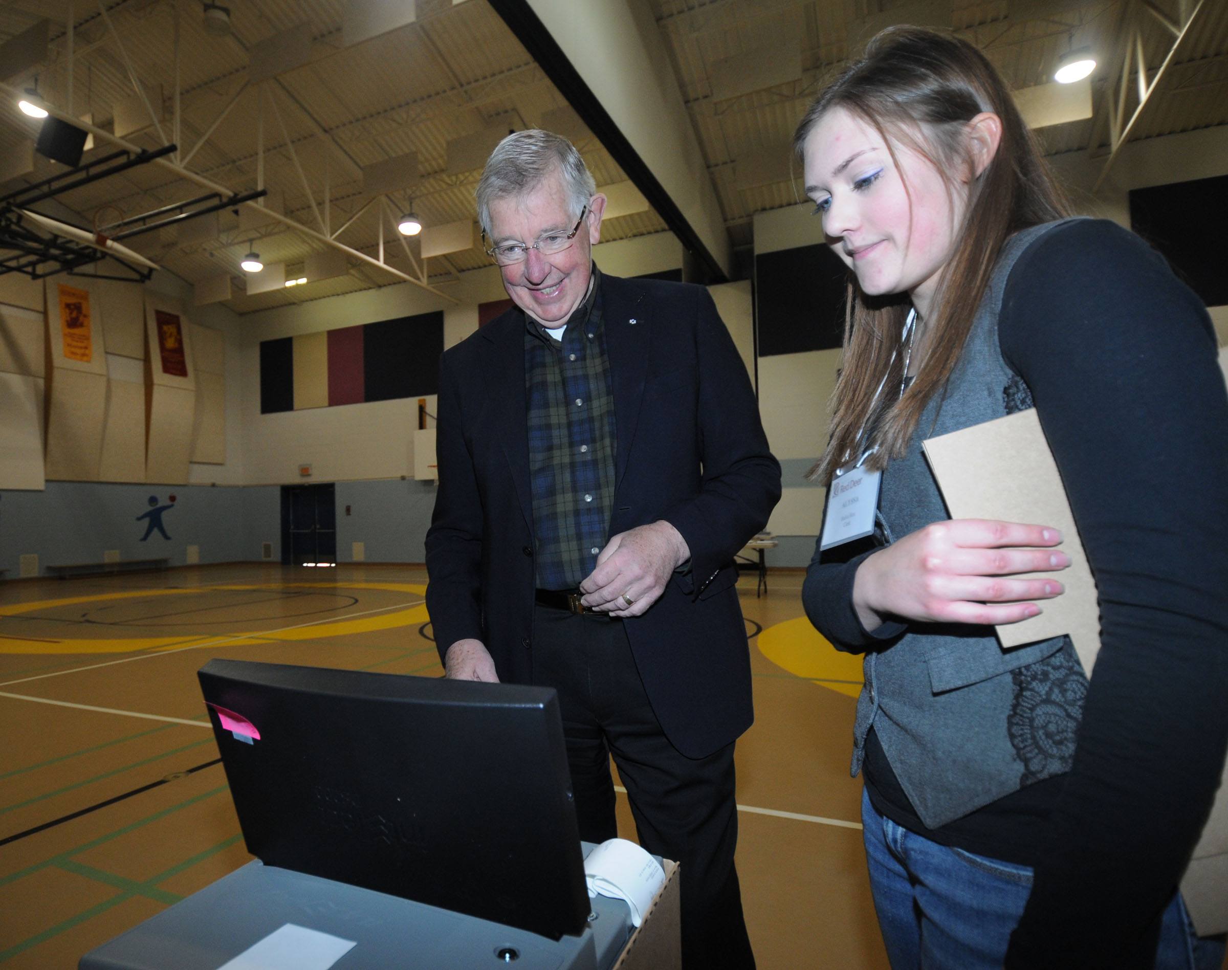 VOTING BEGINS- Mayor Morris Flewwelling waits for his vote to be fed into the ballot counter by Alyssa Stenvig early Monday morning at Mountain View School in Red Deer. Voting ends at 8 p.m.