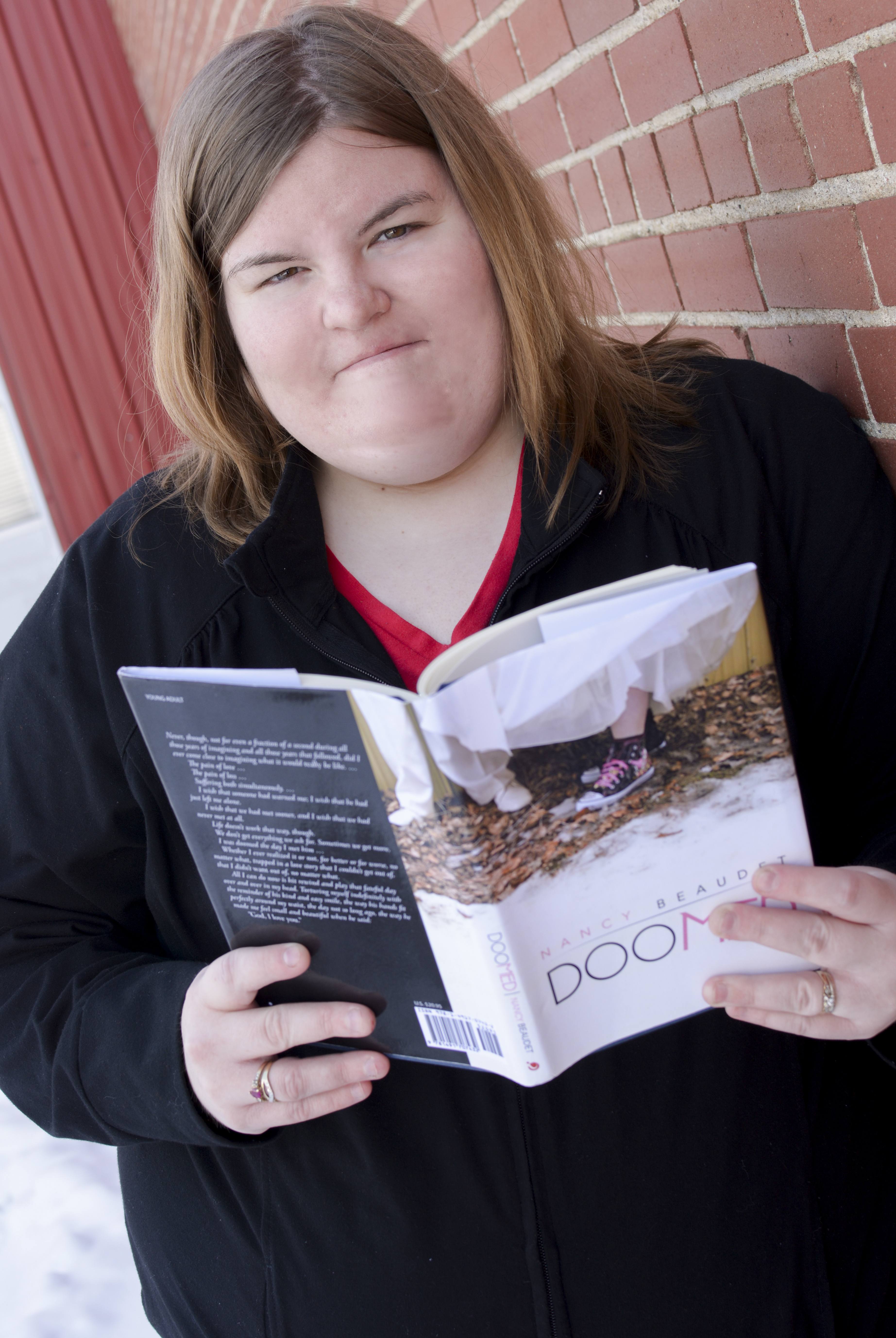 NEW VOICE – Local author Nancy Beaudet holds a copy of her first novel Doomed