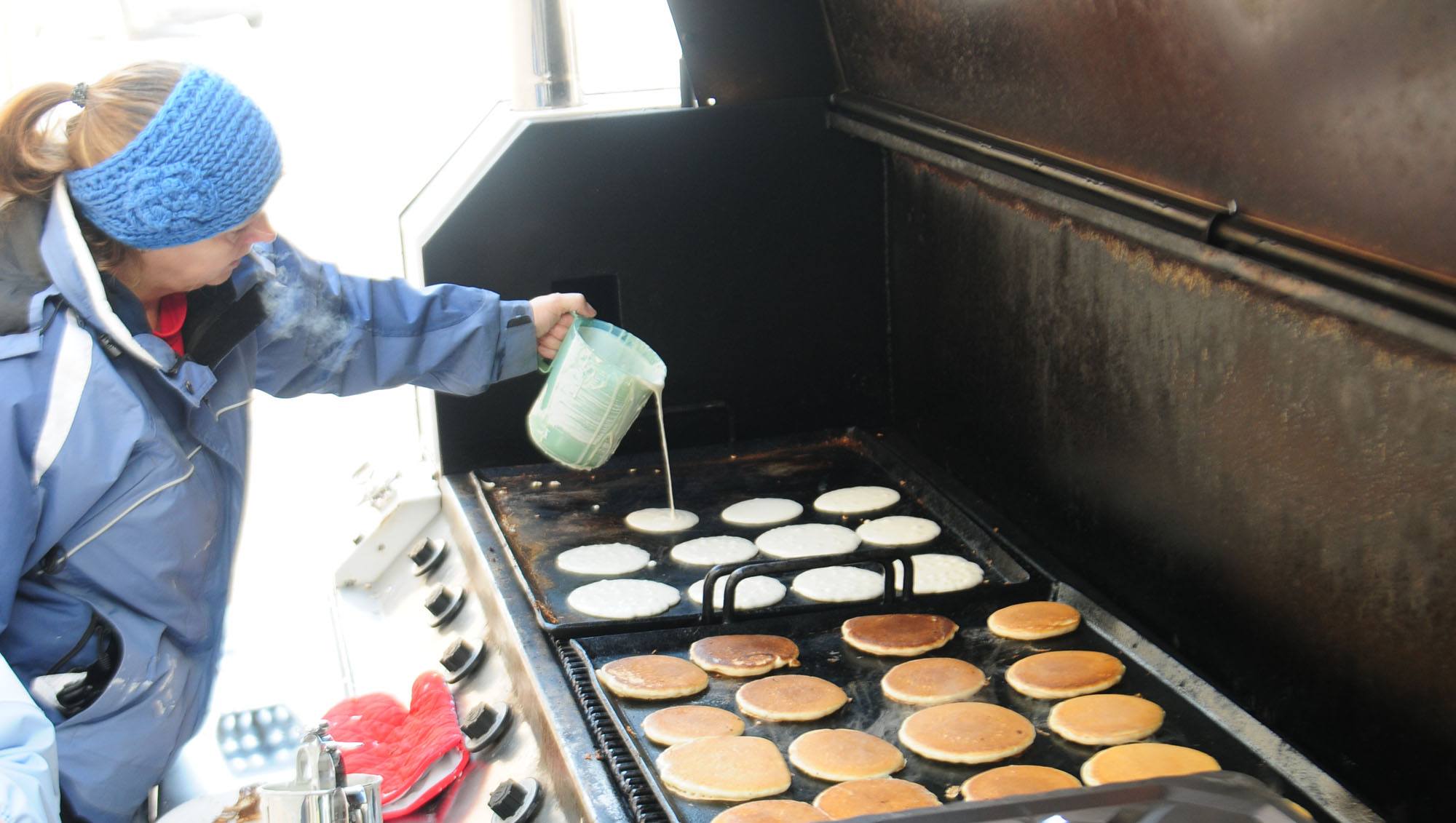 GREAT CAKES- Linda Waschuk pours some pancake batter onto a grill this past week for over 700 students and parents to bring awareness to Shrove Tuesday