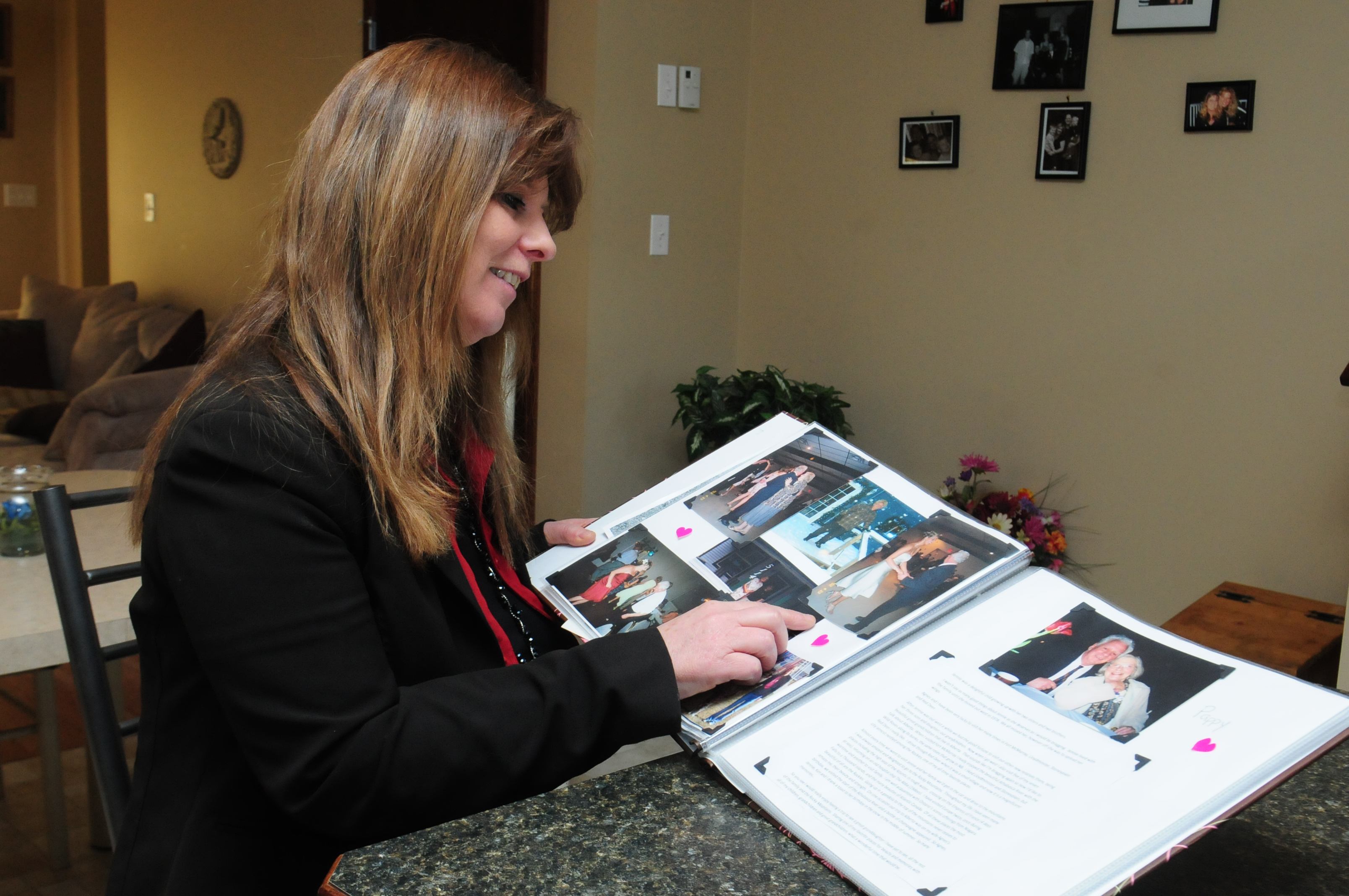 GREAT NEWS—Red Deer’s Jennie Beal looks over a collection of family photos and documents in her home. Beal recently won $25