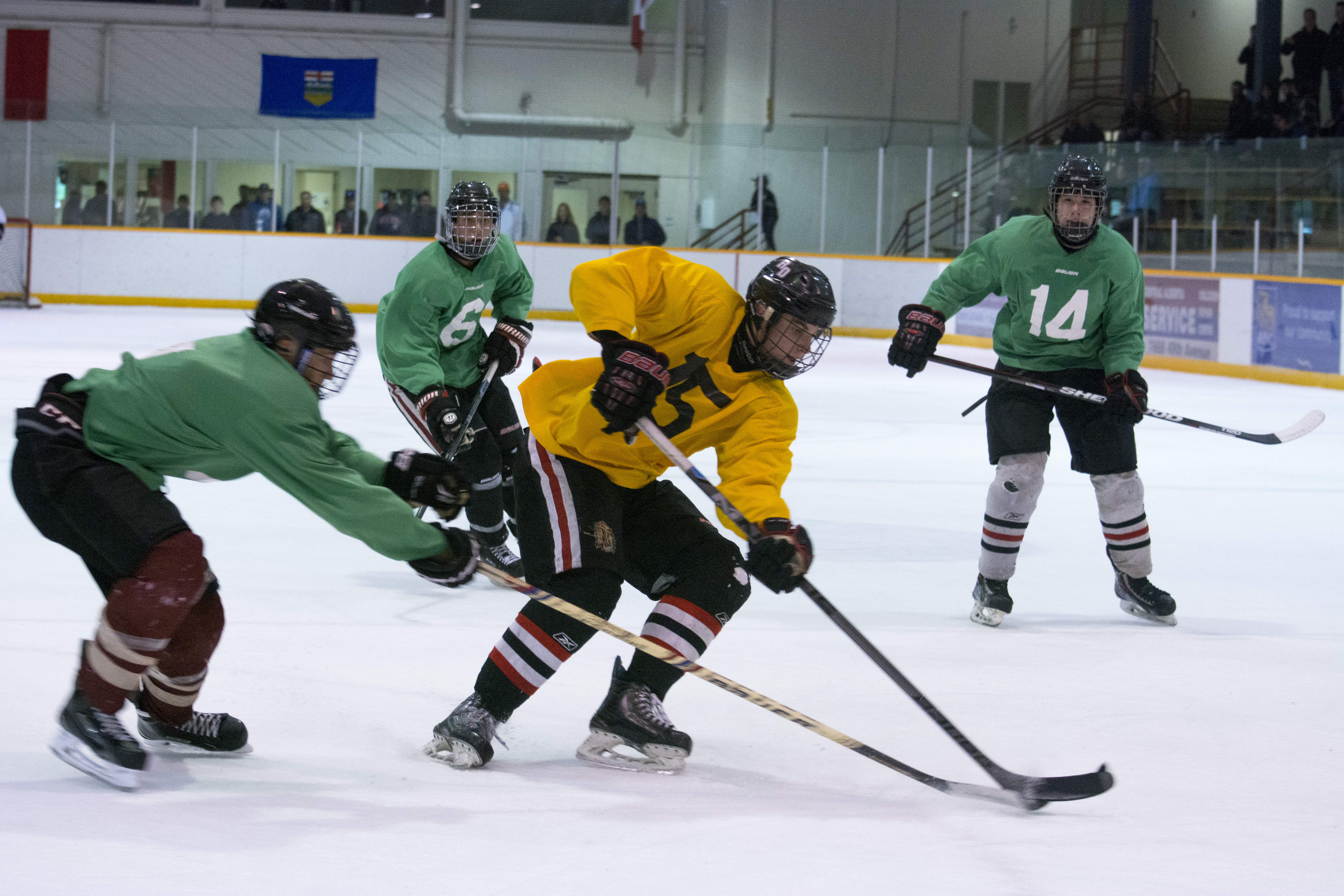 TRYOUTS BEGIN – Red Deer Midget ‘AAA’ Optimist Chiefs began their tryouts last Friday. J. Bussard (yellow) pushes the puck up the ice under heavy coverage from green players.