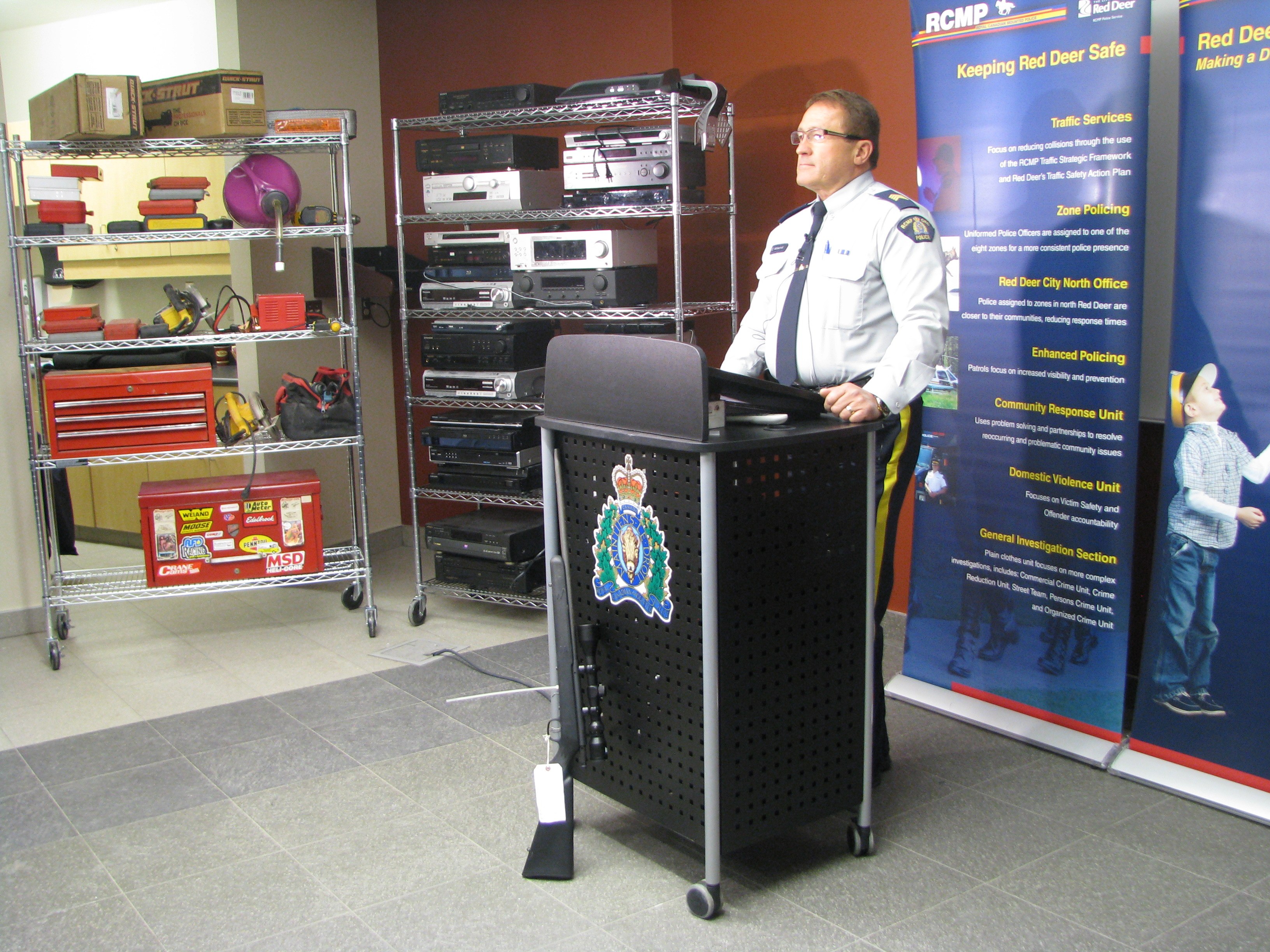 SEIZURE – Staff Sgt. Chris Matechuk of the Innisfail RCMP speaks during a press conference last week held at the downtown RCMP detachment regarding an investigation that led to the seizure of a large amount of stolen property. Displayed behind Matechuk are a number of items that were seized from a Penhold home. Gary Raymond Auvigne has been charged.