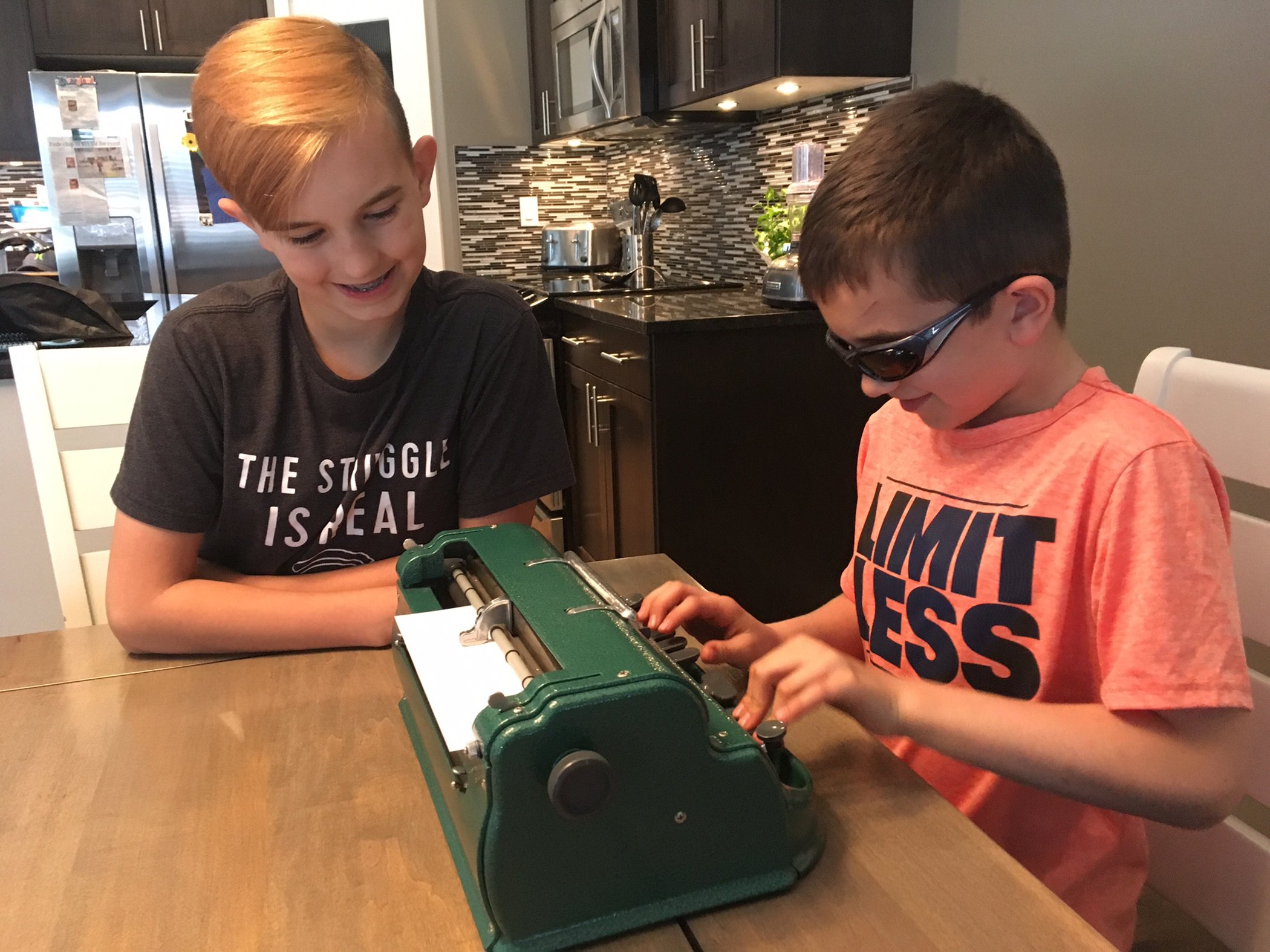 SPECIAL BOND - Caden Johnson (right) types in braille while his brother Brady