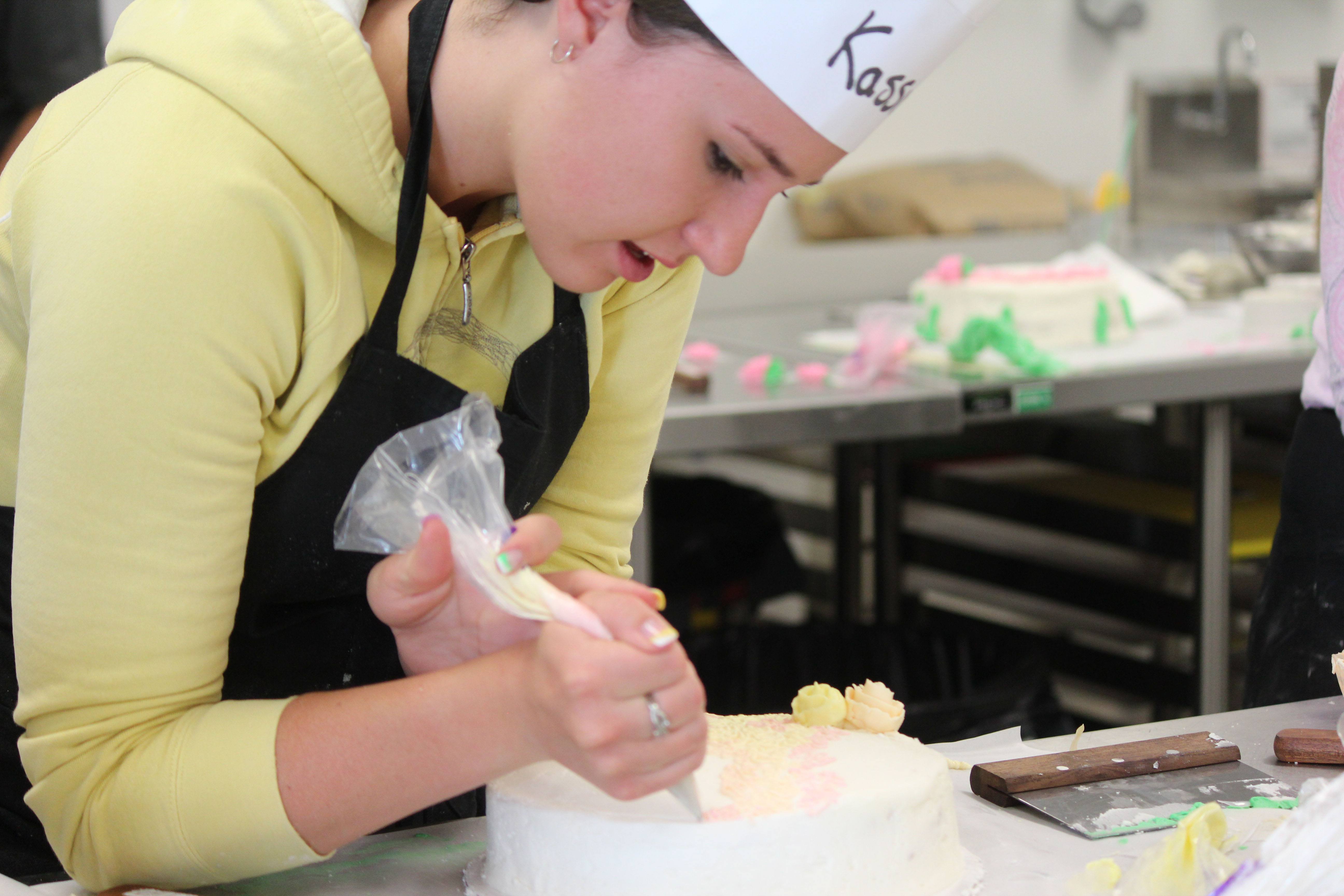 ICING- Kassie Scholze puts some finishing touches on her cake she was decorating as part of a workshop at RDC on the weekend.