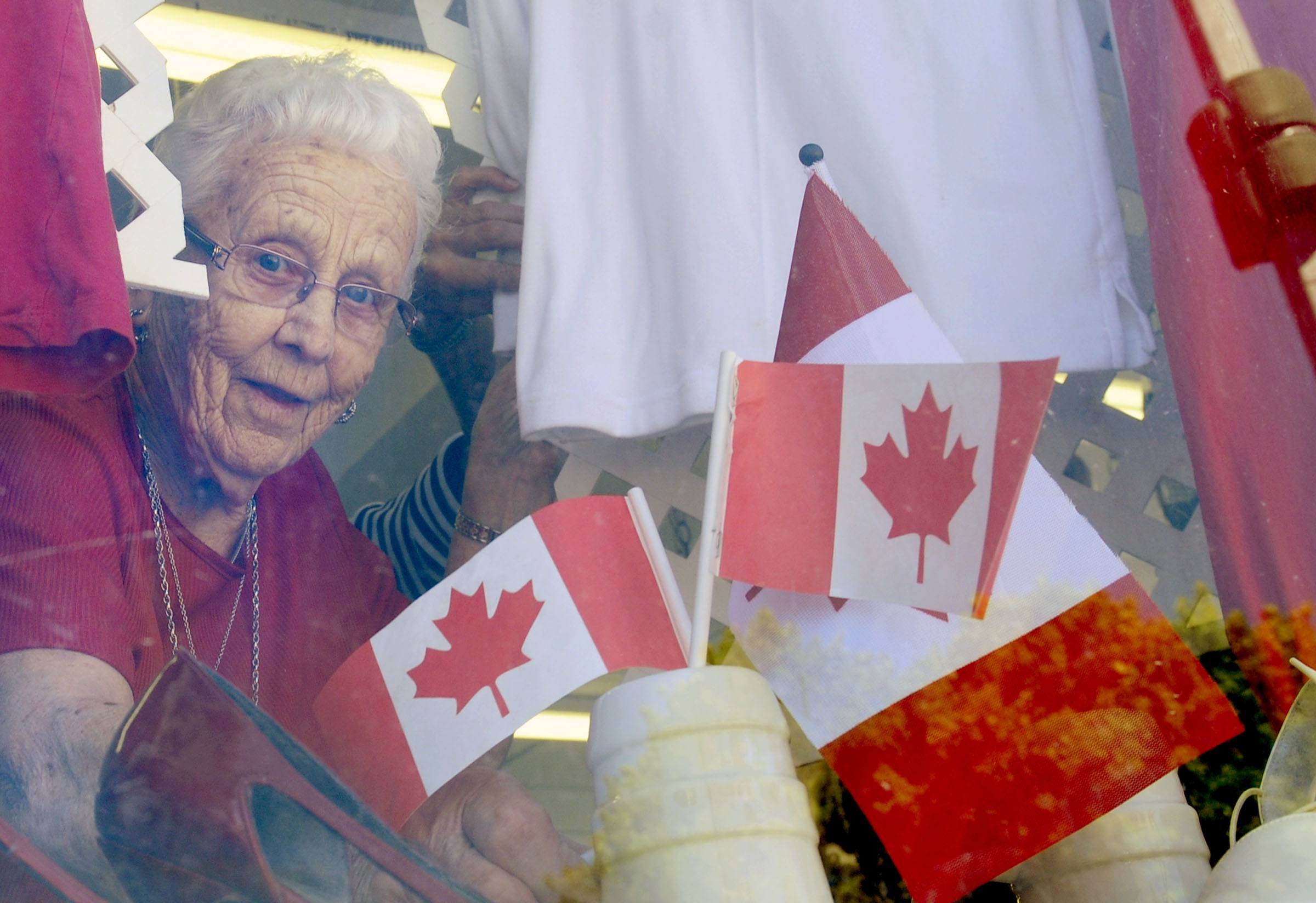 An elderly woman sets up Canada Day decorations downtown to get ready for the special event.