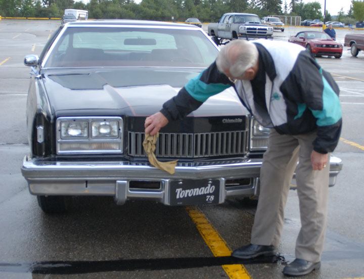 NEW TOY- Don Durand dries the car he bought on Monday after it rained at the Thursday Cruise Night at Parkland Mall.