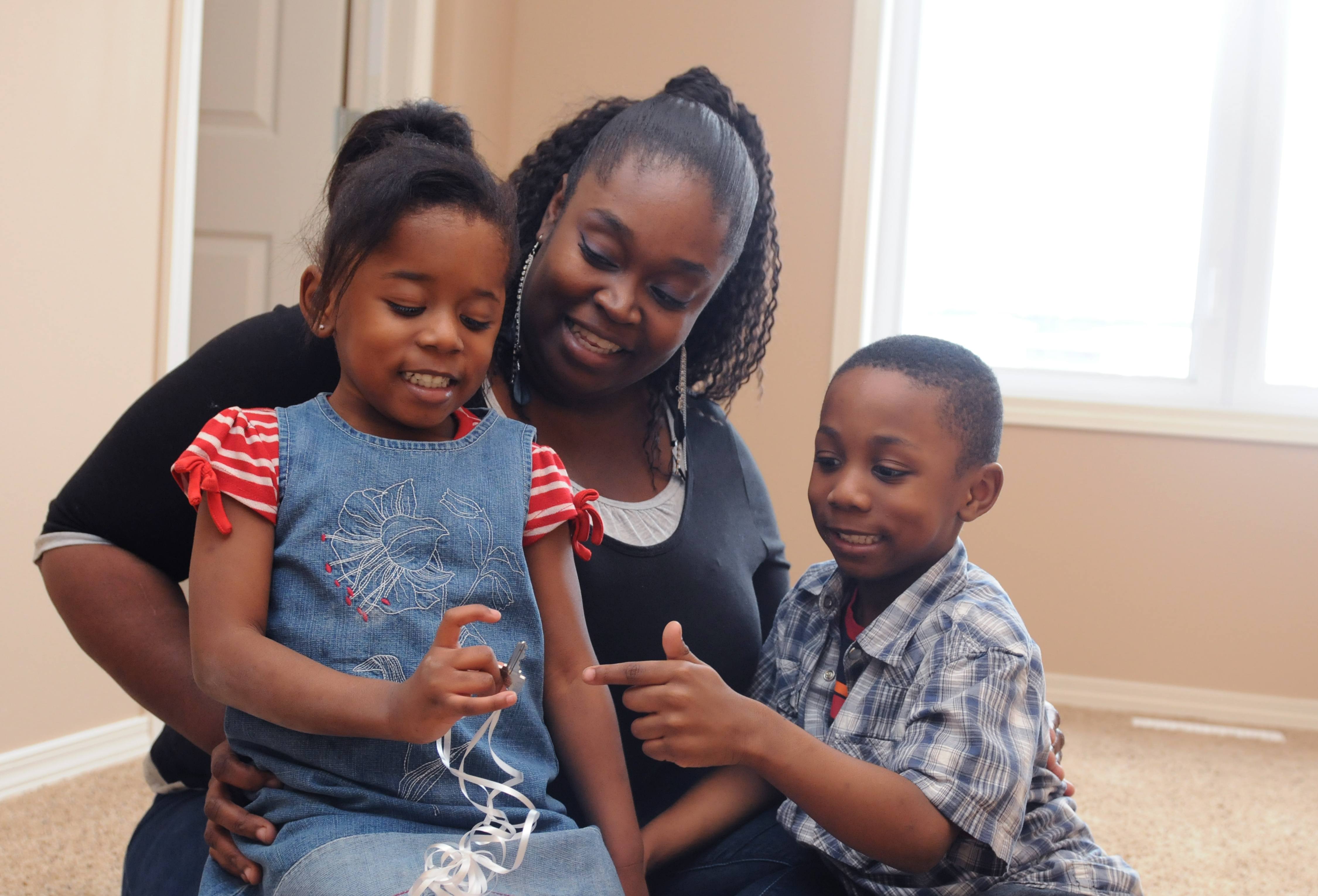 NEW BEGINNING- Ami Vincent sits in her new master bedroom with her two children Faith