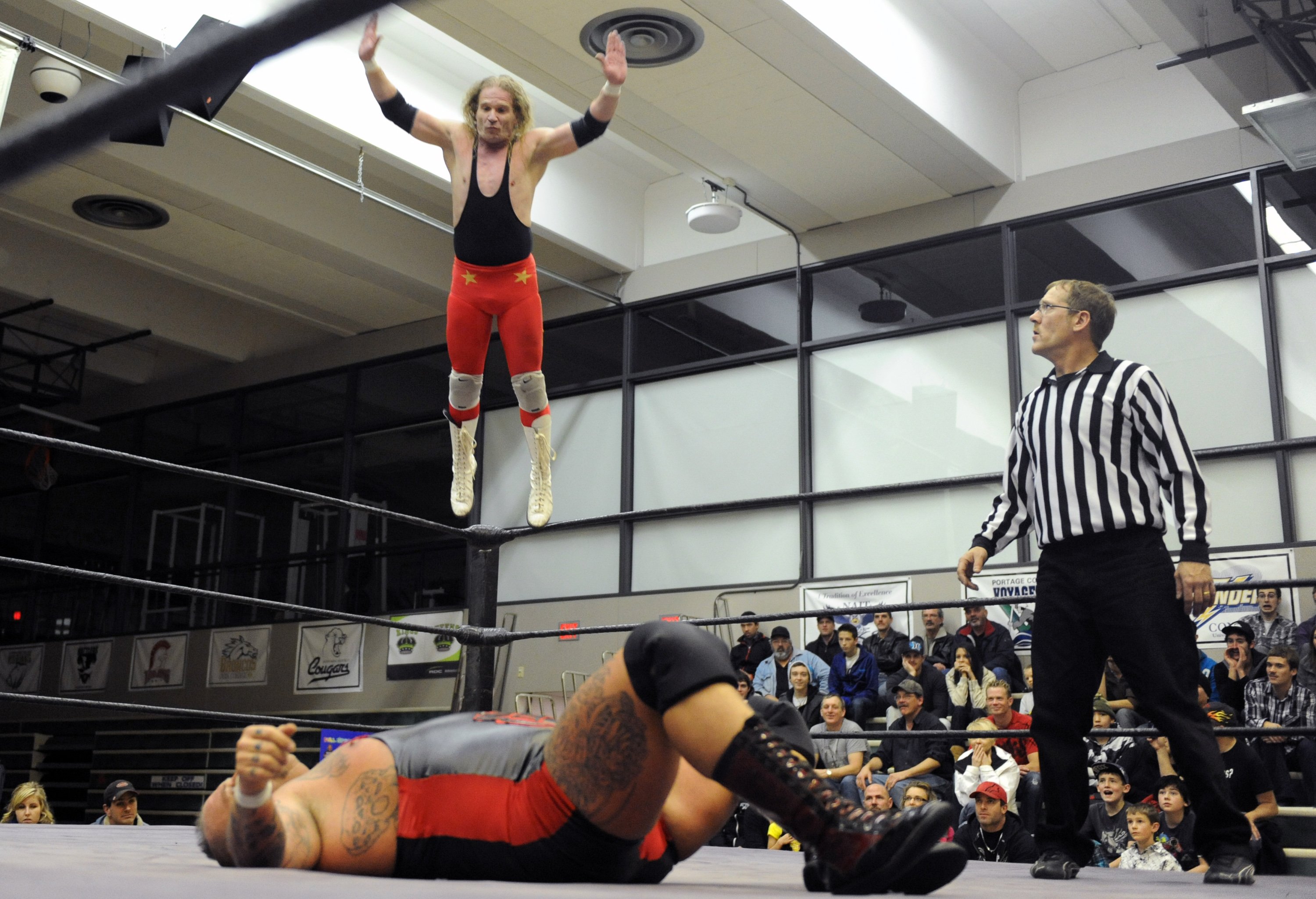 BODY SLAM- Wrestler Mr. Intensity takes a leap off of the ropes onto Massive Damage. The two wrestlers along with others battled it out Saturday night at the college during CNWA wrestling.