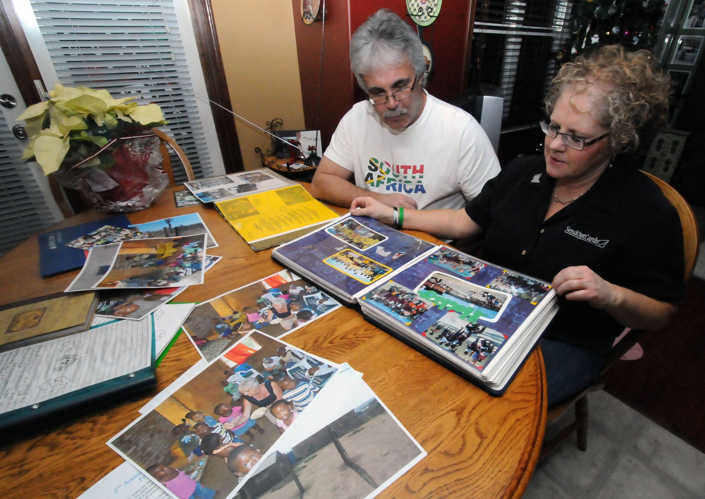 HELPING AFRICA- Scott and Jo-Ann Grimwood look over a scrapbook they made from his travels to Africa. They’ve helped raise money for schools and other needed facilities through the Seed of Hope organization.