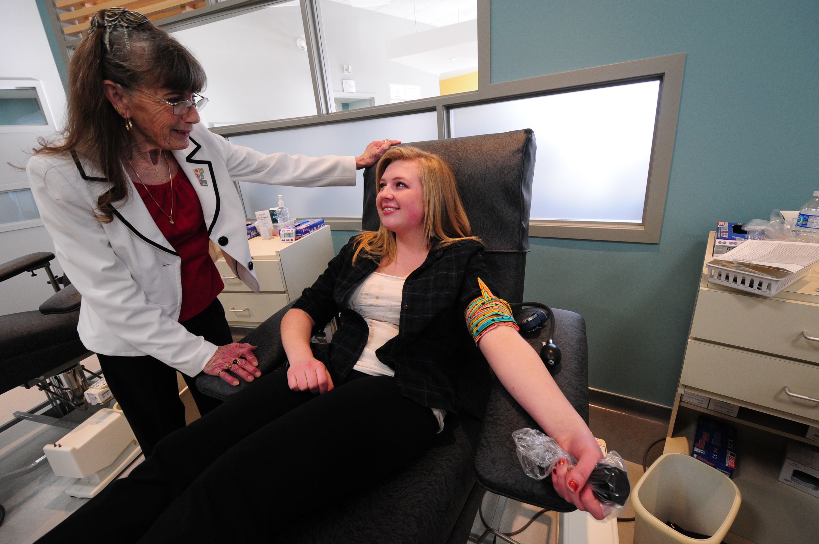 GRAND RE-OPENING- Long time donor Elizabeth Van Slyke talks to Emily Grose from Lindsay Thurber High School while she gives blood during the grand re-opening last week.