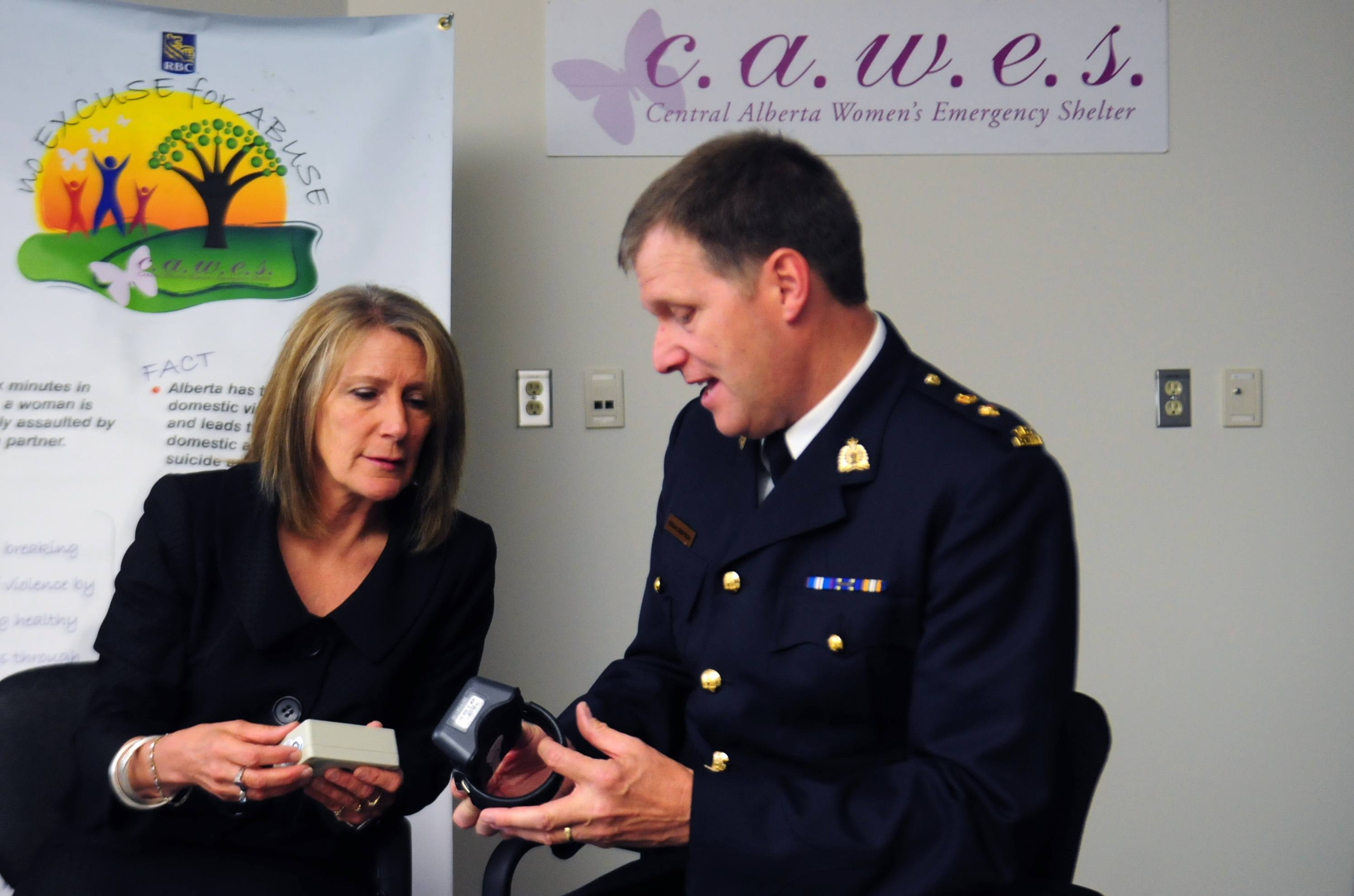 ANKLE BRACELET-  RCMP Supt. Brian Simpson looks over one of 10 ankle bracelets with Brenda Rebman