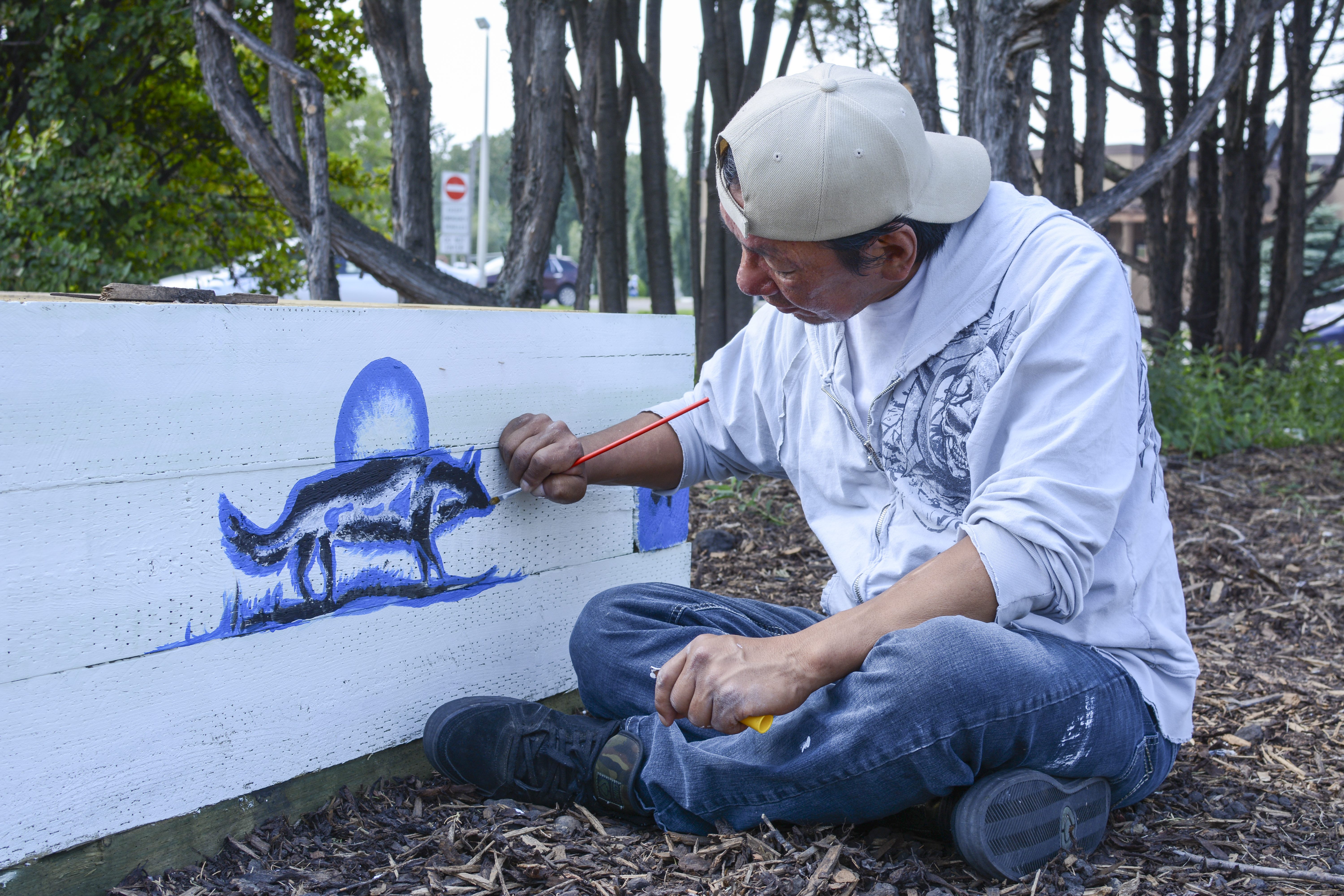 COMMUNITY SPIRIT – Virgil Frencheater paints a mural on the side of a community garden downtown after being commissioned by the City of Red Deer.