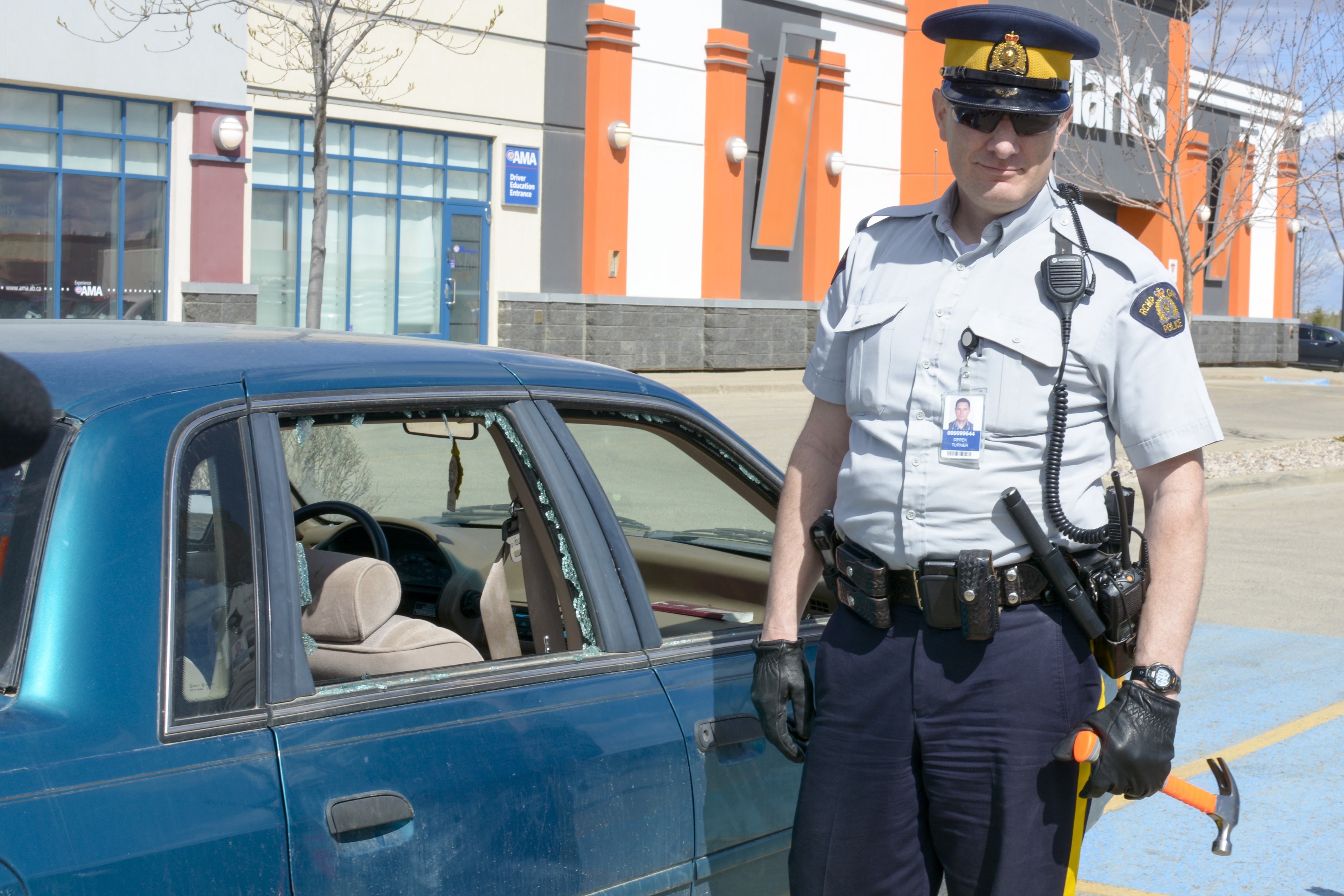 DYNAMIC DEMO – Const. Derek Turner displays how easily a criminal can penetrate the windows of a vehicle using a hammer if they see something valuable. Const. Turner smashed the windows of this Ford Mercury with little to no effort showing it is very easy for criminals to do.