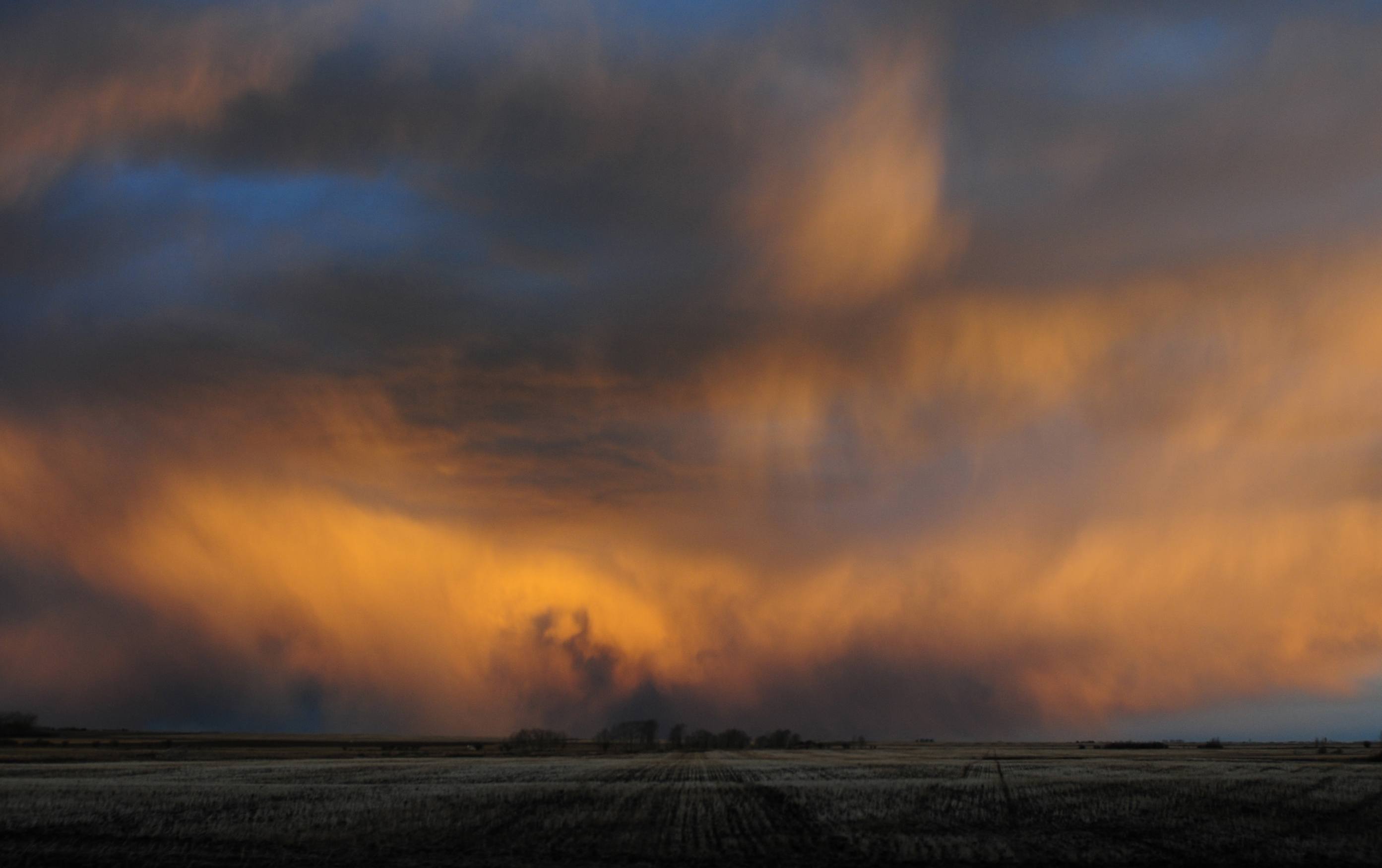 SOMETHINGS BREWING- Storm clouds loom overhead as the sun paints them orange recently. More snow is predicted to fall this Friday as temperatures drop.