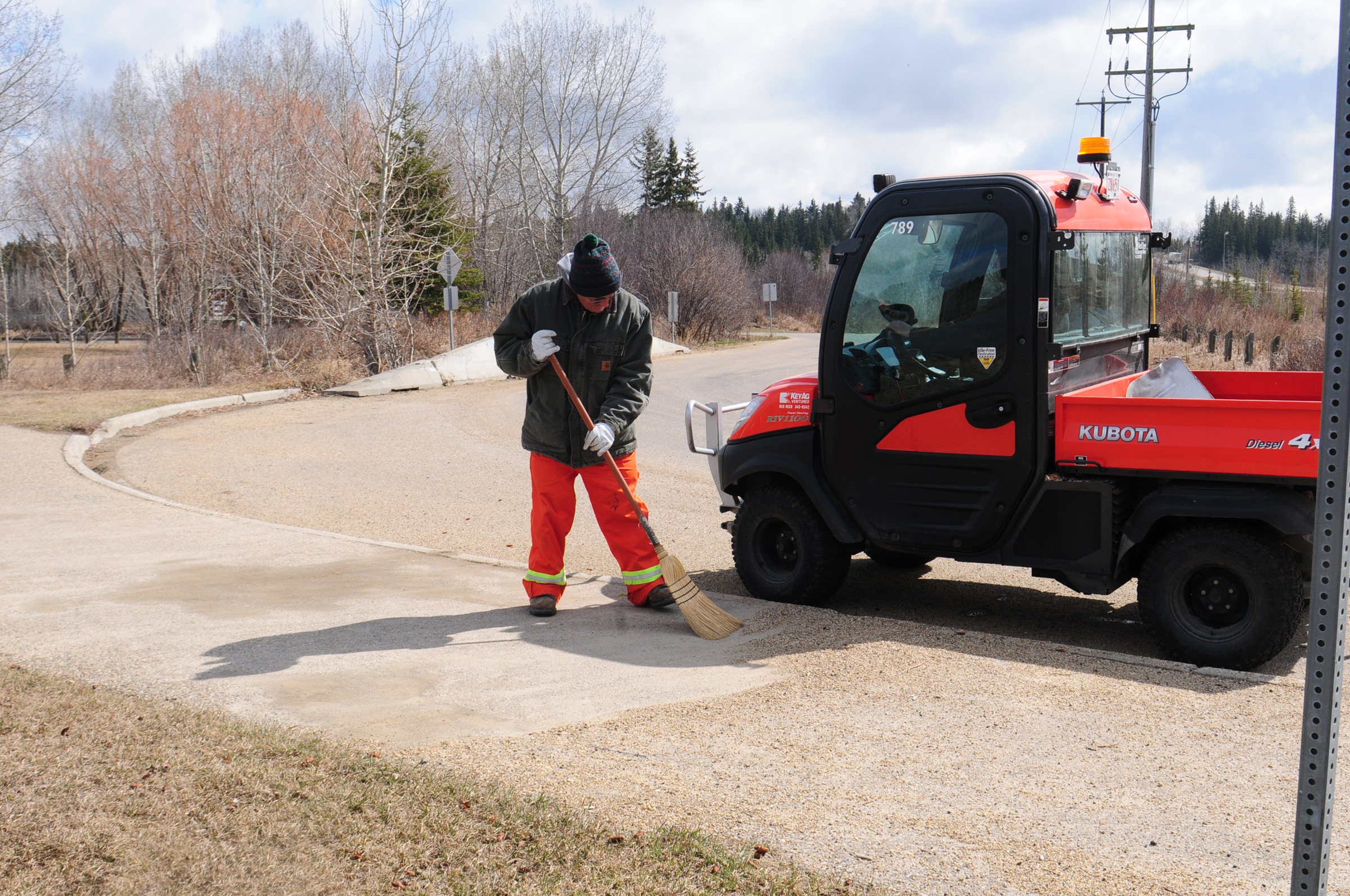 QUICK CLEANING- Lorne Clifford sweeps off a sidewalk near McKenzie Park recently to get the dust and rocks off for pedestrians.