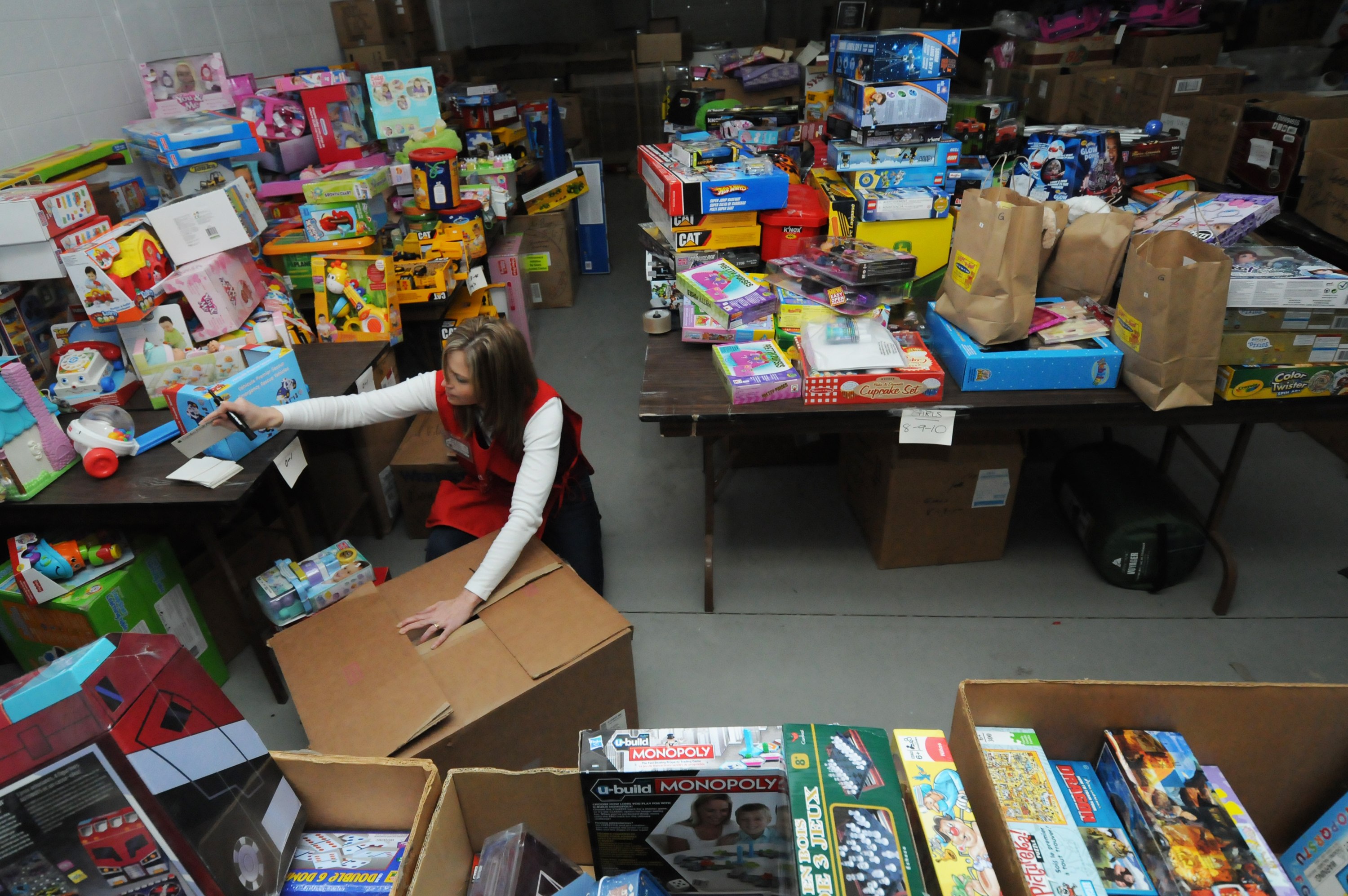 COMMUNITY SUPPORT- Stacey Davey tapes up a box of gifts as volunteers help sort out the haul of toys that Red Deerians donated to the local Christmas Bureau over the weekend.