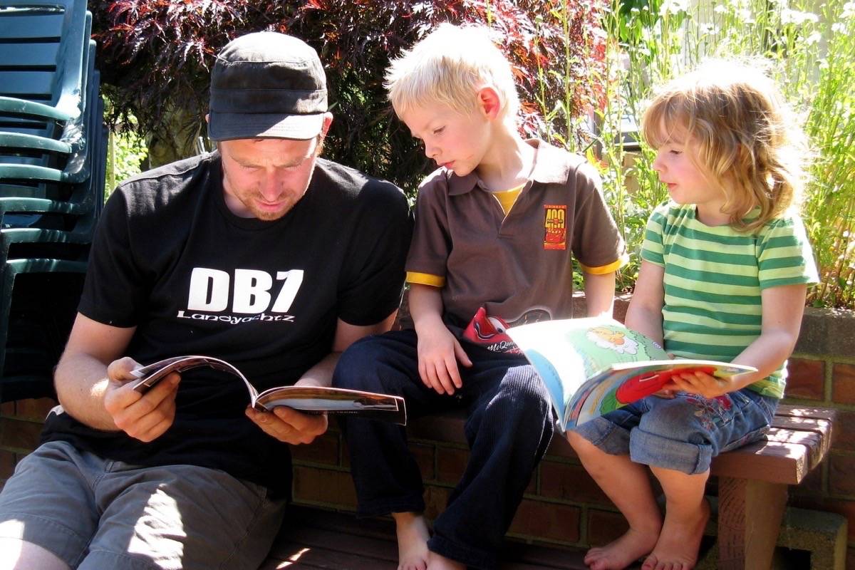 A father reads with his kids on Father’s Day (Paul Hamilton/Flickr)