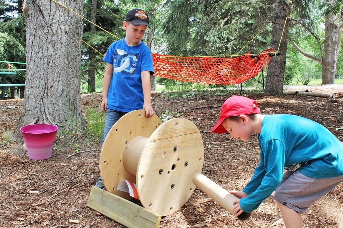 BUILDING AWAY- From left, Dylan Walsh, 8, and Jayden Zadrozny, 5, put together some wooden pieces, letting their imagination wild at the Adventure Playground event held at Kerry Wood Nature Centre Friday.                                Carlie Connolly/Red Deer Express