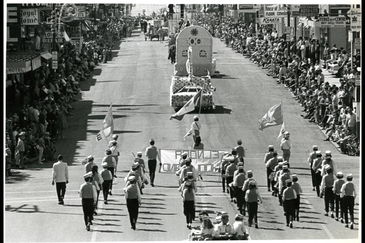 CELEBRATION - Red Deer Exhibition parade proceeding south on Gaetz Avenue, Aug. 1st, 1967. Note the floats and flags celebrating the Canadian Centennial. Red Deer Archives P3778