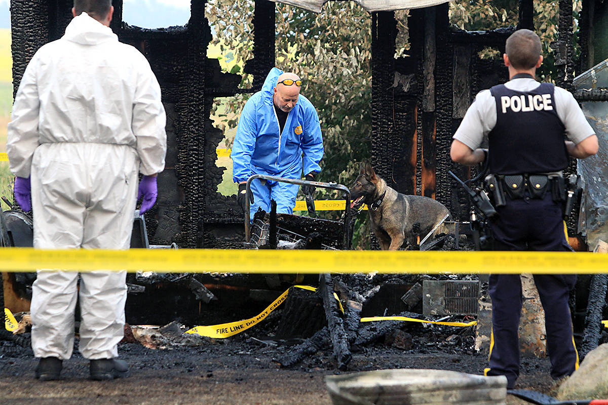 RCMP and members of the Ponoka County East District Fire Department assist a special forensics investigator and his sniffer dog July 19. The investigation stemmed from a fire in an outbuilding that left one man with burn injuries. Photo by Jordie Dwyer                                INVESTIGATION - RCMP and members of the Ponoka County East District Fire Department assist a special forensics investigator and his sniffer dog July 19th. The investigation stemmed from a fire in an outbuilding that left one man with burn injuries. Jordie Dywer/Ponoka News