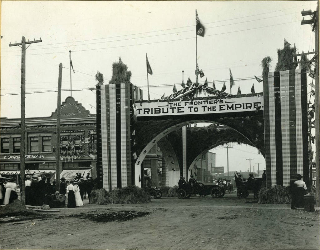 SPECIAL VISIT - Motorcade with Sir Wilfrid Laurier and other dignitaries proceeding under the special archway erected at the intersection of Ross Street and Gaetz Avenue for the Prime Minister’s visit in August 1910. The downtown entrance sign at the intersection of Gaetz Avenue and 52nd St. was inspired by the historic Laurier arch. Red Deer Archives P253