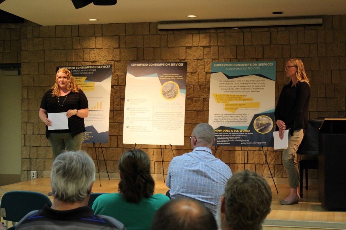 COMMUNITY ENGAGEMENT - Sarah Fleck and Rebecca Hare of the Turning Point Society talk to a group regarding a supervised drug consumption site in Red Deer on Tuesday night. Carlie Connolly/Red Deer Express