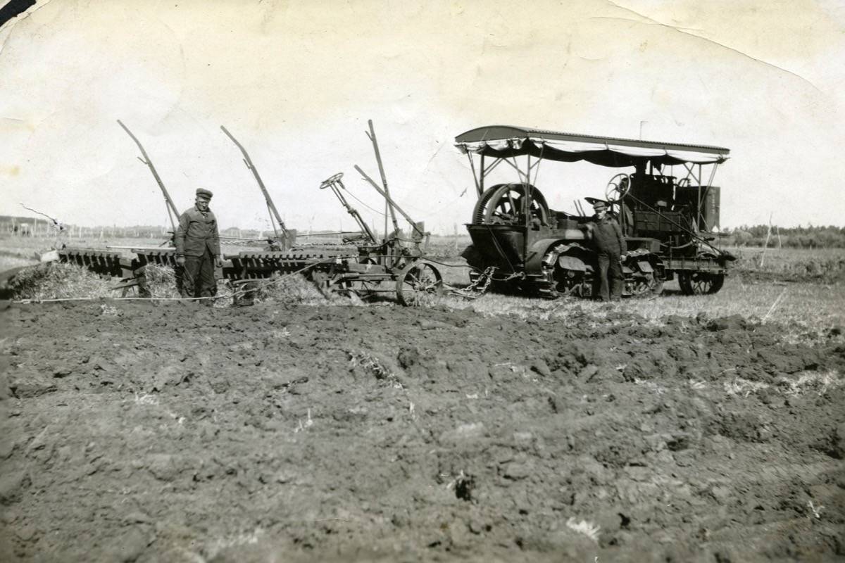 HISTORIC - Ross (Buzz) Van Slyke (right) with three Van Slyke plows being pulled by a Canadian Holt caterpillar tractor, August 1912. During this demonstration, which was organized by Michener Brothers on the farm of J.J. Rich, east of Red Deer, the outfit was able to break 15 acres in one day. The tractor used only 10 gallons of gasoline. Red Deer Archives P2213