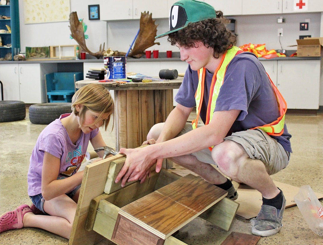 HAMMER IT - Ten-year-old Kera Wolf gets to try out some hammering as Volunteer with Boys and Girls Club Jasper Lind holds the boards steady at the Adventure Playground event held at Kerry Wood Nature Centre June 30th. Carlie Connolly/Red Deer Express