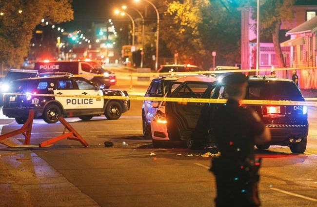 Police investigate the scene where a car crashed into a roadblock in Edmonton Alta, on Saturday September 30, 2017. (Jason Franson/The Canadian Press)