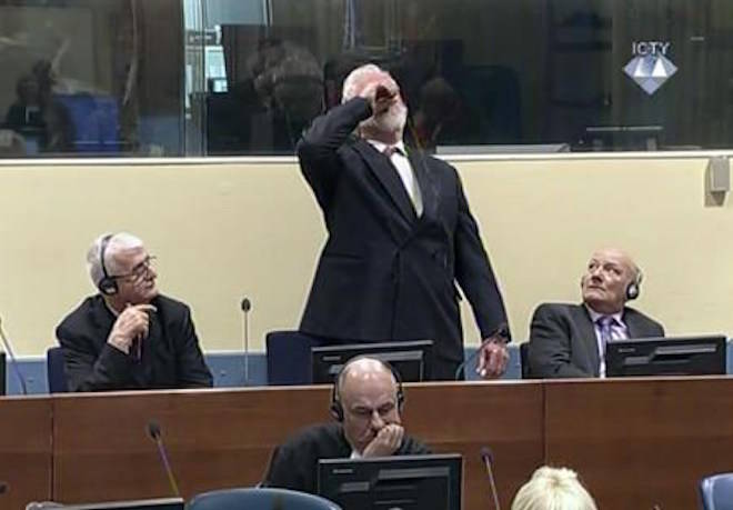 In this photo provided by the ICTY on Wednesday, Nov. 29, 2017, Slobodan Praljak brings a bottle to his lips, during a Yugoslav War Crimes Tribunal in The Hague, Netherlands. (ICTY via AP)