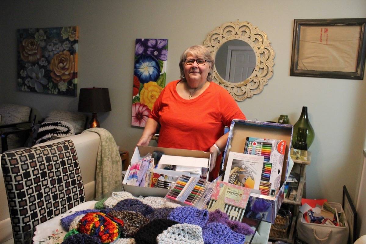 GIVING BACK - Lucille Gaumond stands with her many toques that she’s made for the I Love First Peoples shoebox campaign.                                Carlie Connolly/Red Deer Express