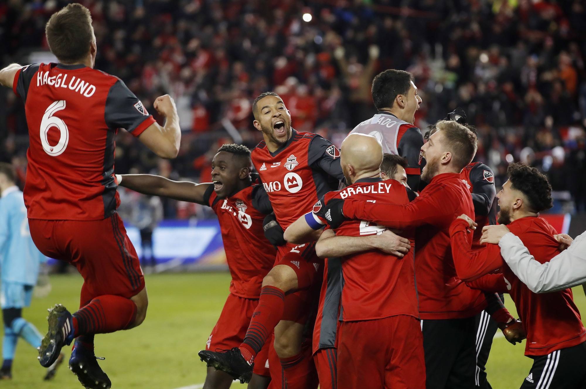 Toronto FC players celebrate a goal by midfielder Victor Vazquez (obscured) in stoppage time against the Seattle Sounders during second-half MLS Cup final soccer action in Toronto, Saturday, Dec. 9, 2017. (Mark Blinch/The Canadian Press via AP)