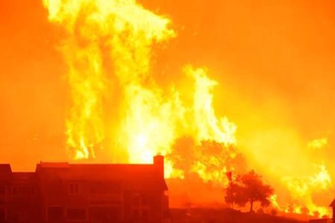 In this Sunday, Dec. 10, 2017 photo released by Santa Barbara County Fire Department, flames advance on homes off Shepard Mesa Road at 5:45 Sunday morning in Carpinteria, Calif. (Mike Eliason/Santa Barbara County Fire Department via AP)