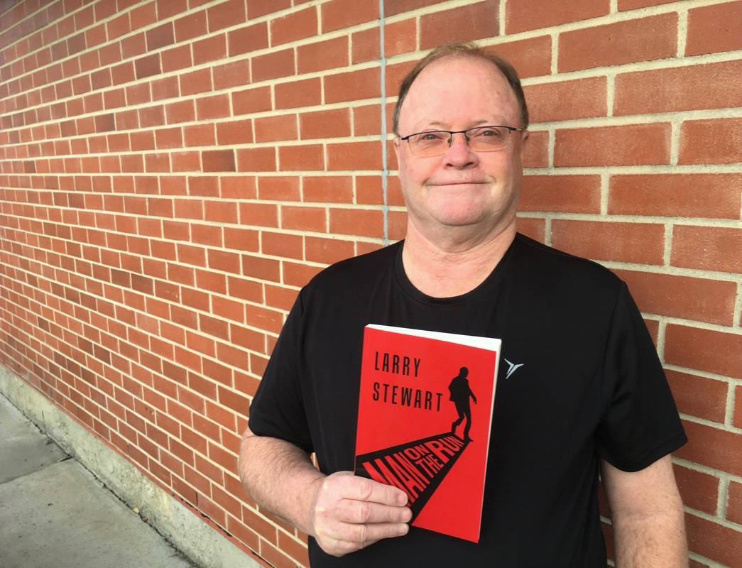LITERARY ADVENTURE                                City resident Larry Stewart posed with his brand new book Man on the Run. A book signing is set for this weekend in Red Deer.                                Mark Weber/Red Deer Express