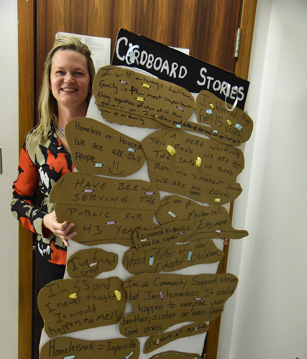 SHARING THEIR STORIES - Christine Steward, executive director of the Canadian Mental Health Association of Central Alberta holds up the cardboard stories they collected from homeless people, in Red Deer at an event at The HUB on Ross. Michelle Falk/Red Deer Express