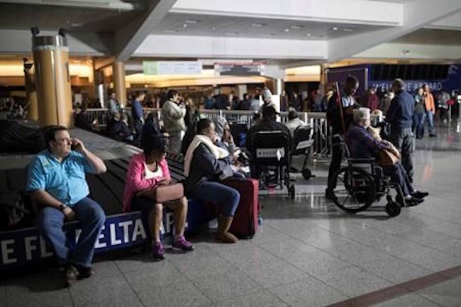 Passengers wait after the lights went out at Hartfield-Jackson Atlanta International Airport, Sunday, Dec. 17, 2017, in Atlanta. (AP Photo/Branden Camp)