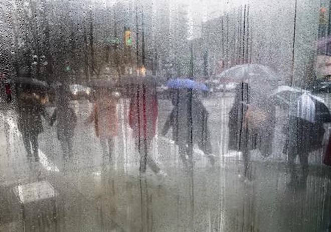 Pedestrians carrying umbrellas to shield themselves from the rain are seen through a cafe window covered with rain and steam in Vancouver, B.C., on Saturday March 11, 2017. It was the year of too much ??? too wet, too dry, too hot, too cool. THE CANADIAN PRESS/Darryl Dyck
