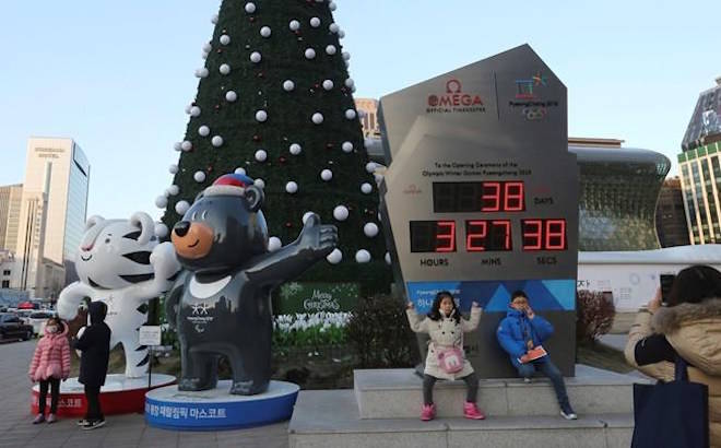 Children pose in front of an electric board that shows the number of days left until the opening of 2018 Pyeongchang Winter Olympic Games as the official mascots, a white tiger “Soohorang” for the Olympic, left, and black bear “Bandabi” for the Paralympic, are displayed in Seoul, South Korea, Tuesday, Jan. 2, 2018. South Korea on Tuesday offered high-level talks with rival North Korea to find ways to cooperate on next month’s Winter Olympics in the South. (AP Photo/Ahn Young-joon)